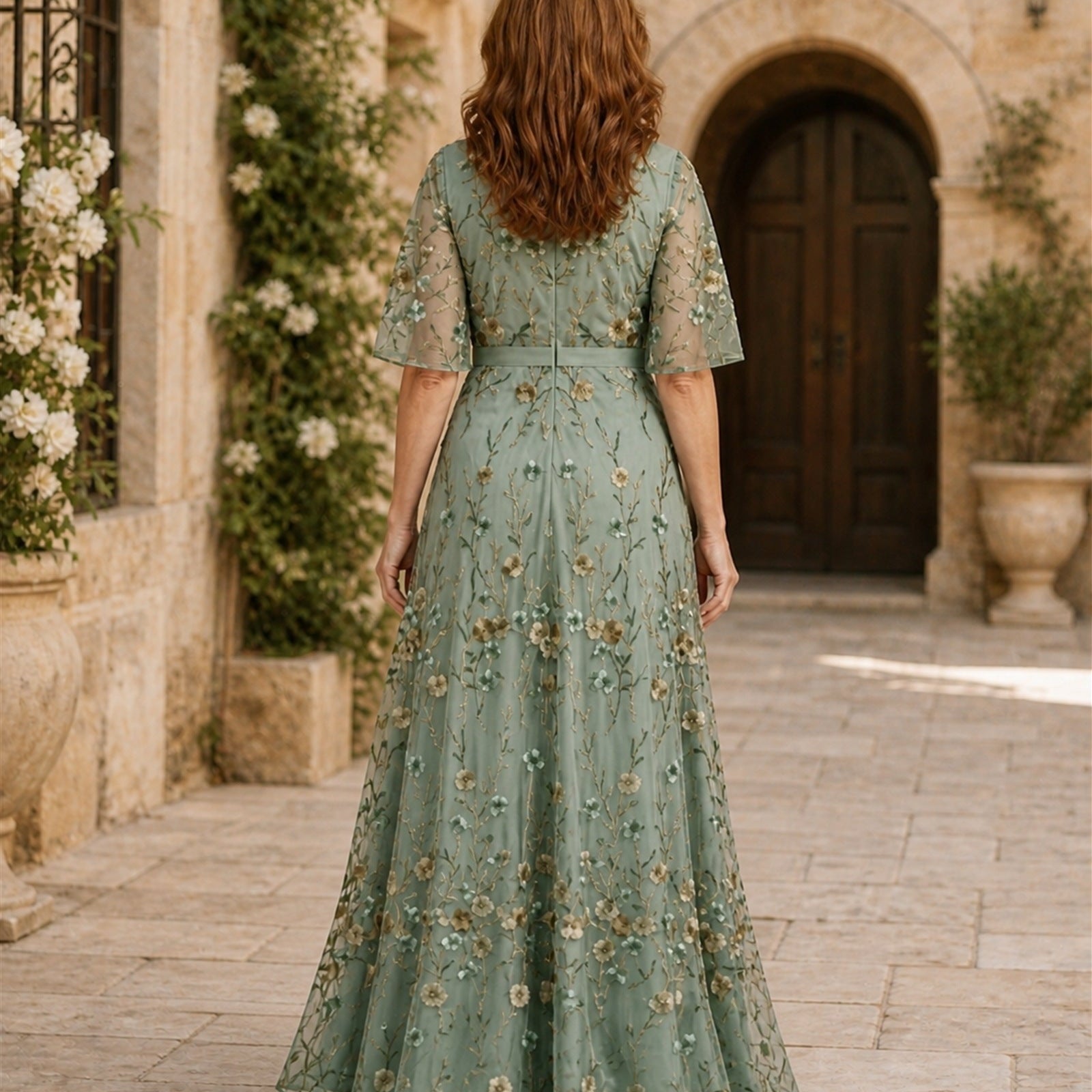 Ana-Roxana în rochie maxi verde salvie cu broderie florală, vedere din spate