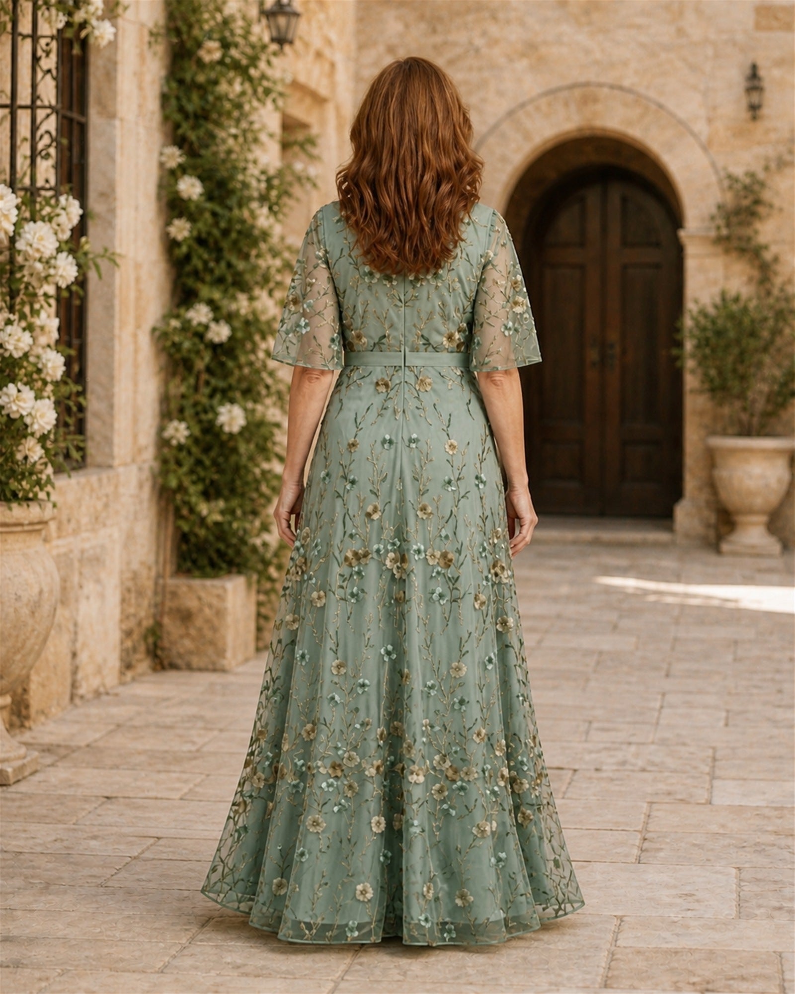 Ana-Roxana în rochie maxi verde salvie cu broderie florală, vedere din spate
