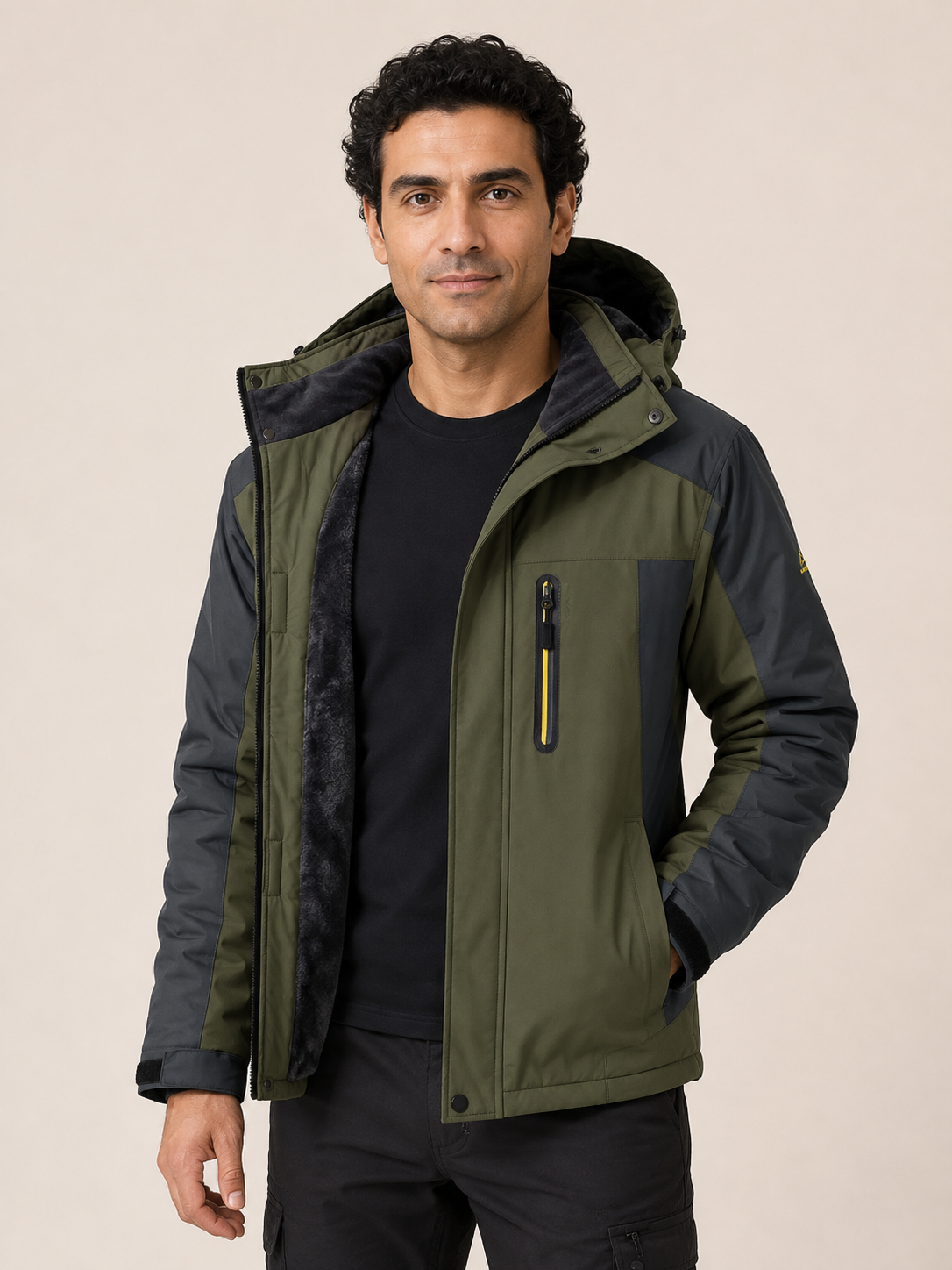 Men's olive and charcoal waterproof technical jacket, worn by model in warm beige studio