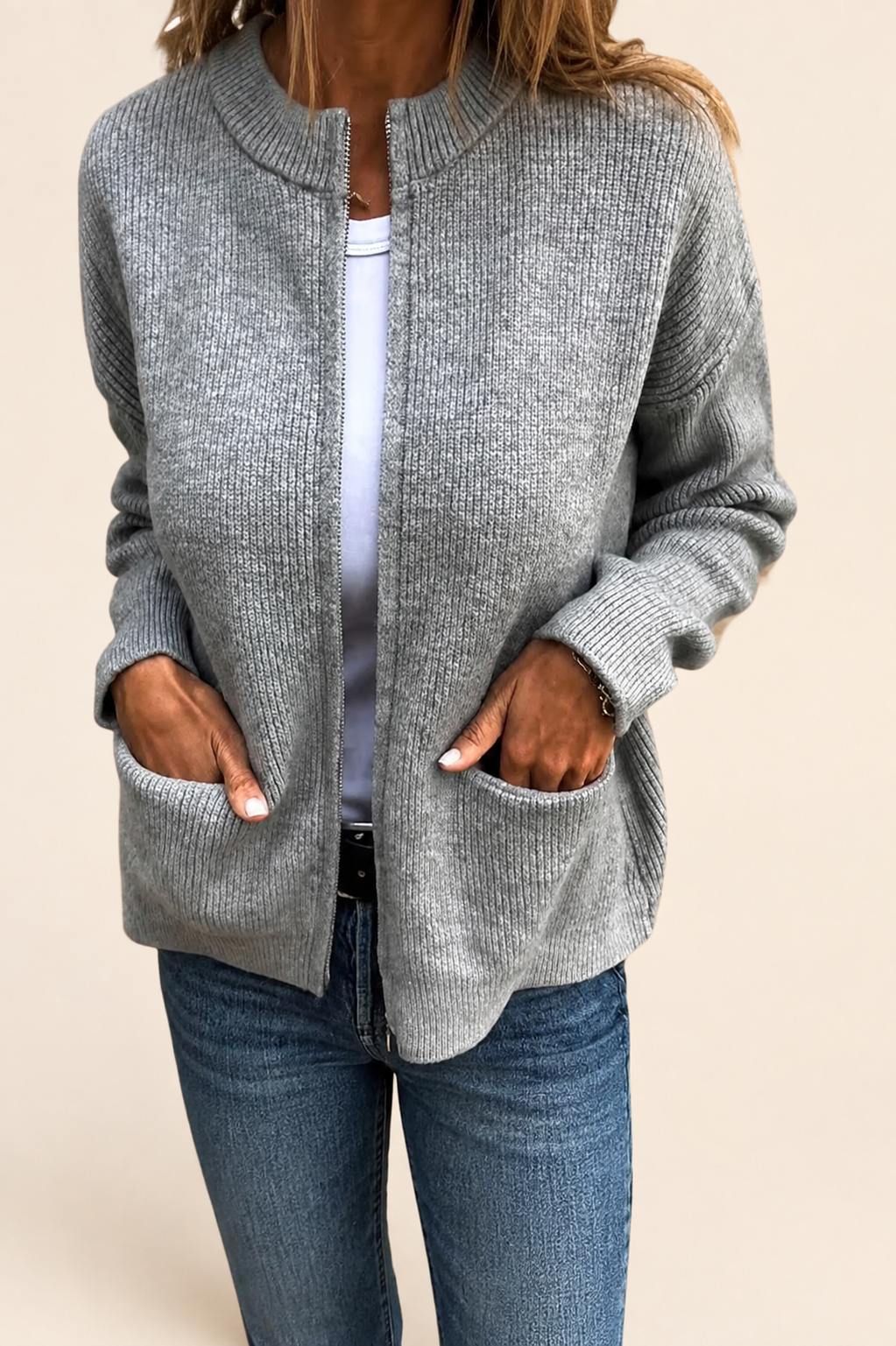 Aino grauer Strickcardigan auf warmem beigem Hintergrund