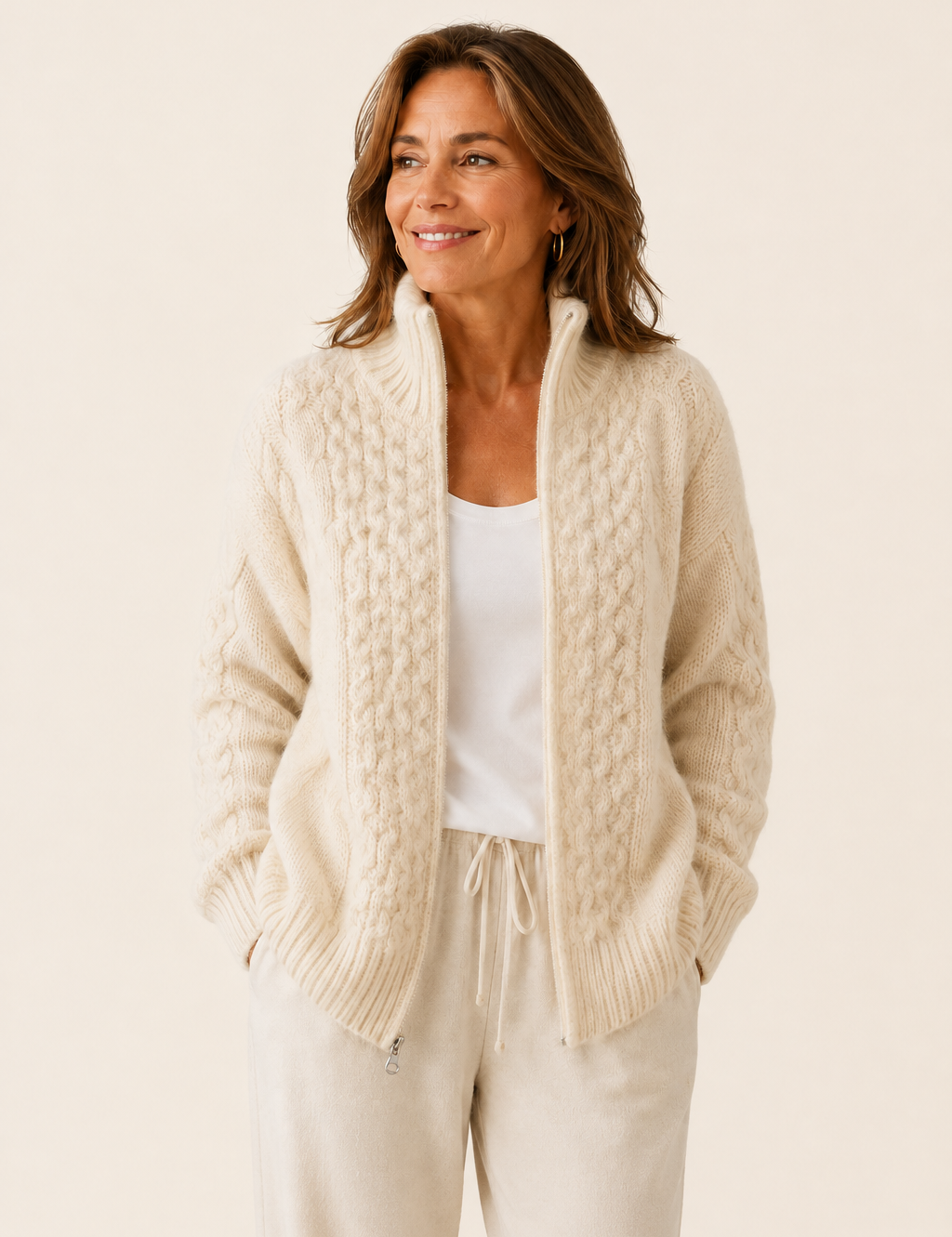 Alina cremefarbene Zip-Strickjacke auf warmem beigem Hintergrund