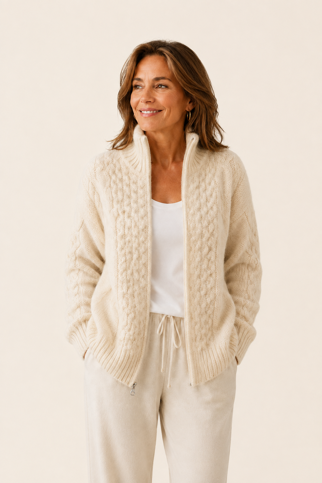 Alina cremefarbene Zip-Strickjacke auf warmem beigem Hintergrund
