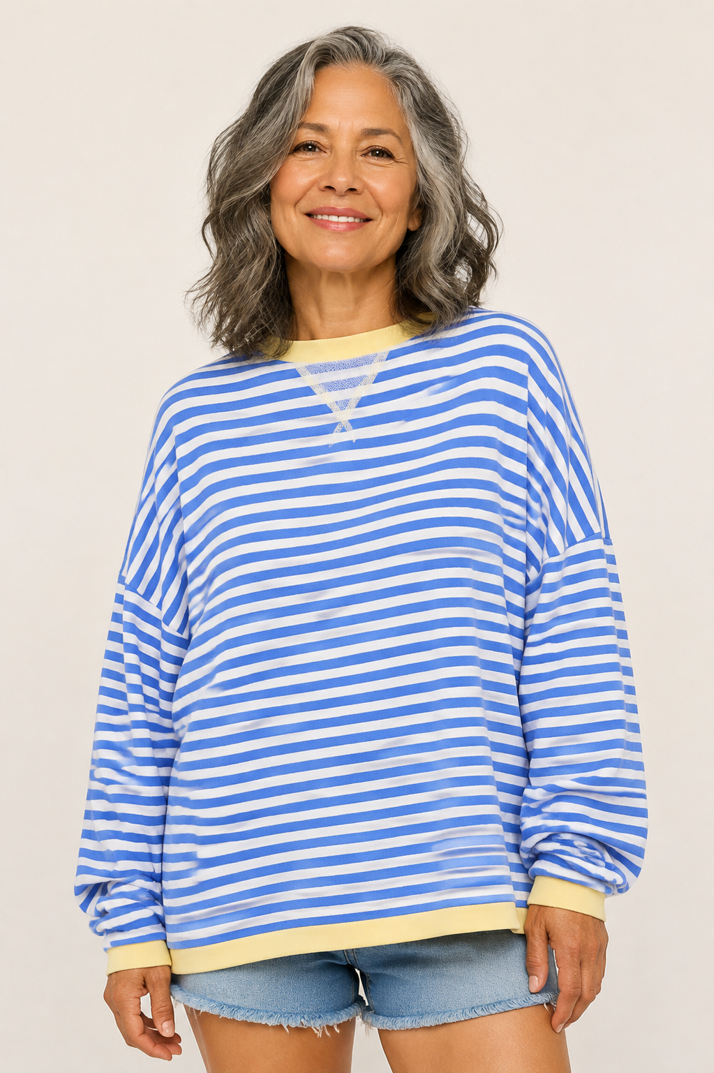 Ana-Daniela blau-weiß gestreifter Oversize-Pullover an reifer Frau auf warmem beigem Hintergrund