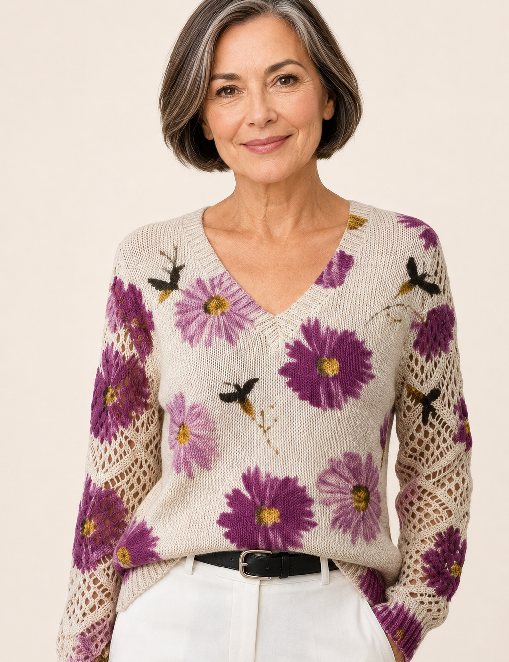 Aura cremefarbener Blumenpullover an reifer Frau auf warmem beigem Hintergrund