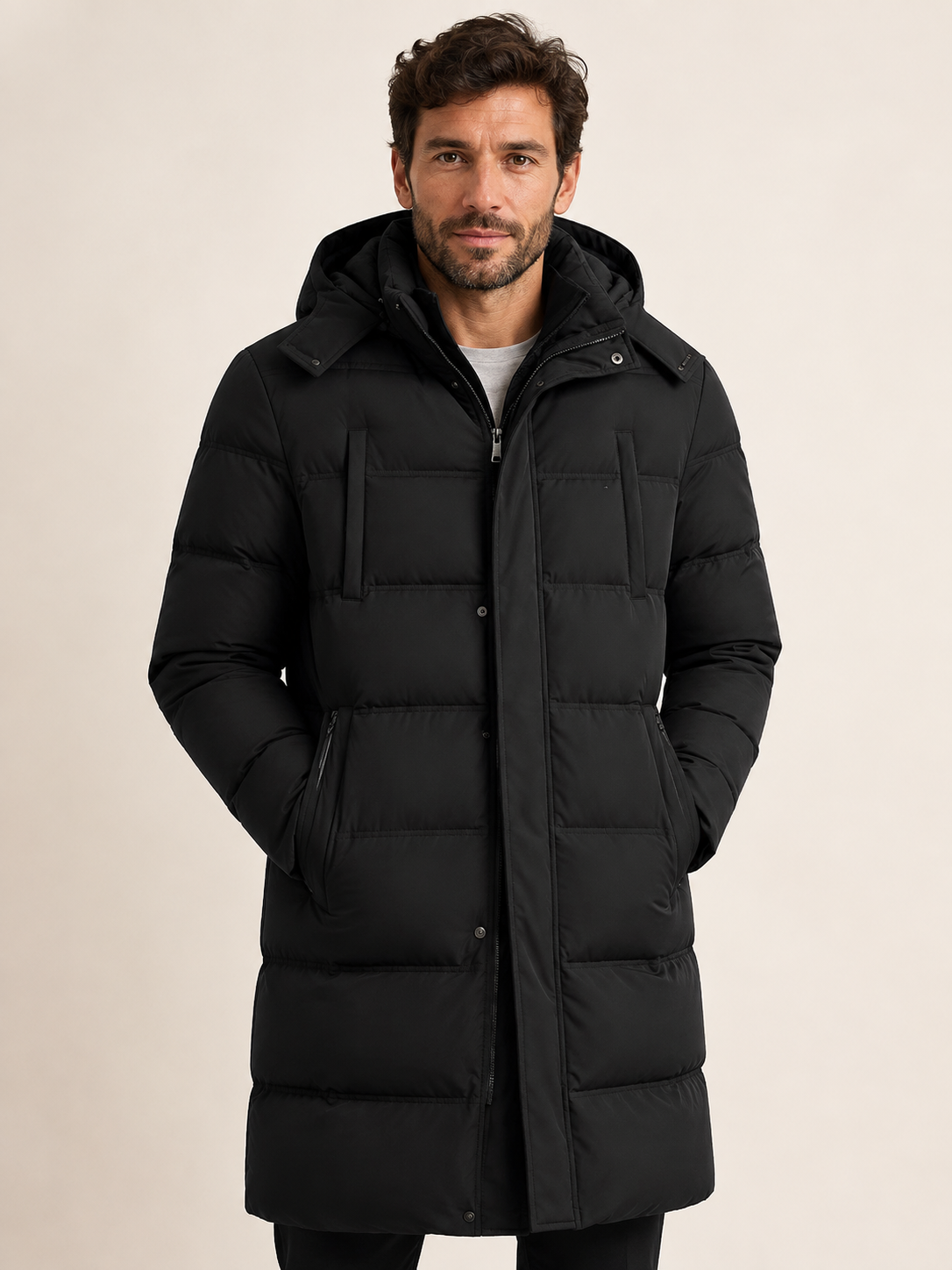 Schwarze Longline-Pufferjacke an Mann auf warmem beigem Hintergrund