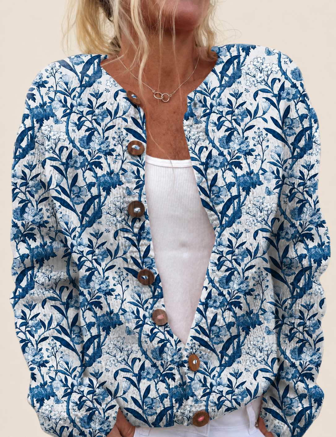 Cardigan mit blau-weißem Blumenprint – warmbeiger Studiohintergrund