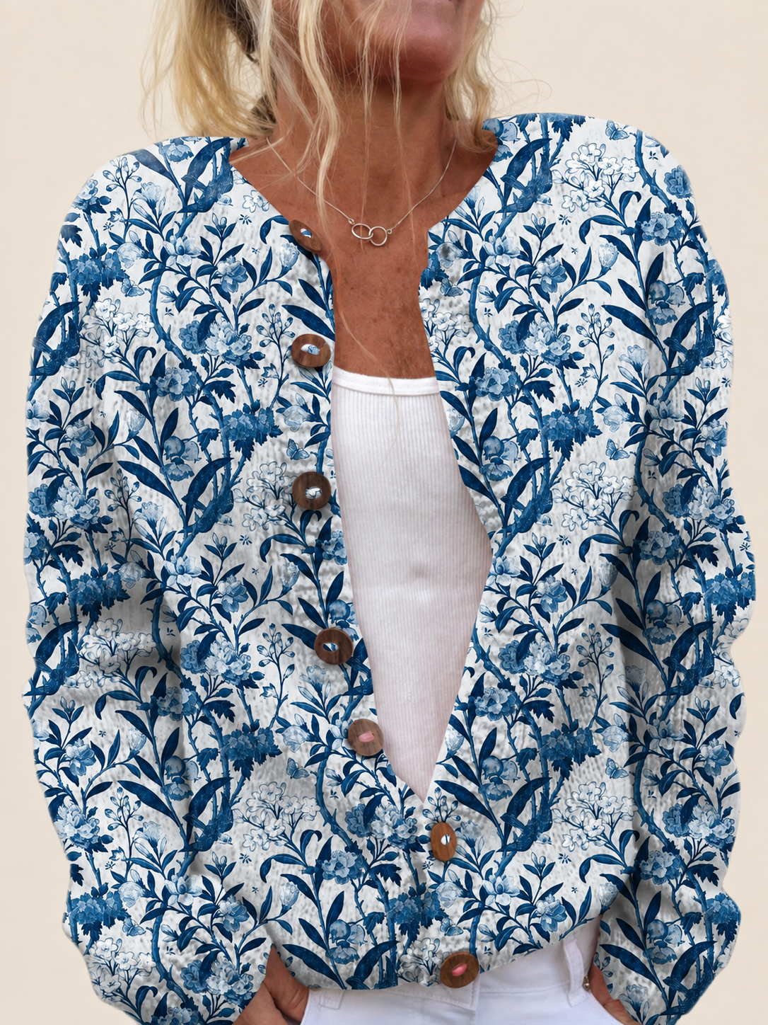 Cardigan mit blau-weißem Blumenprint – warmbeiger Studiohintergrund