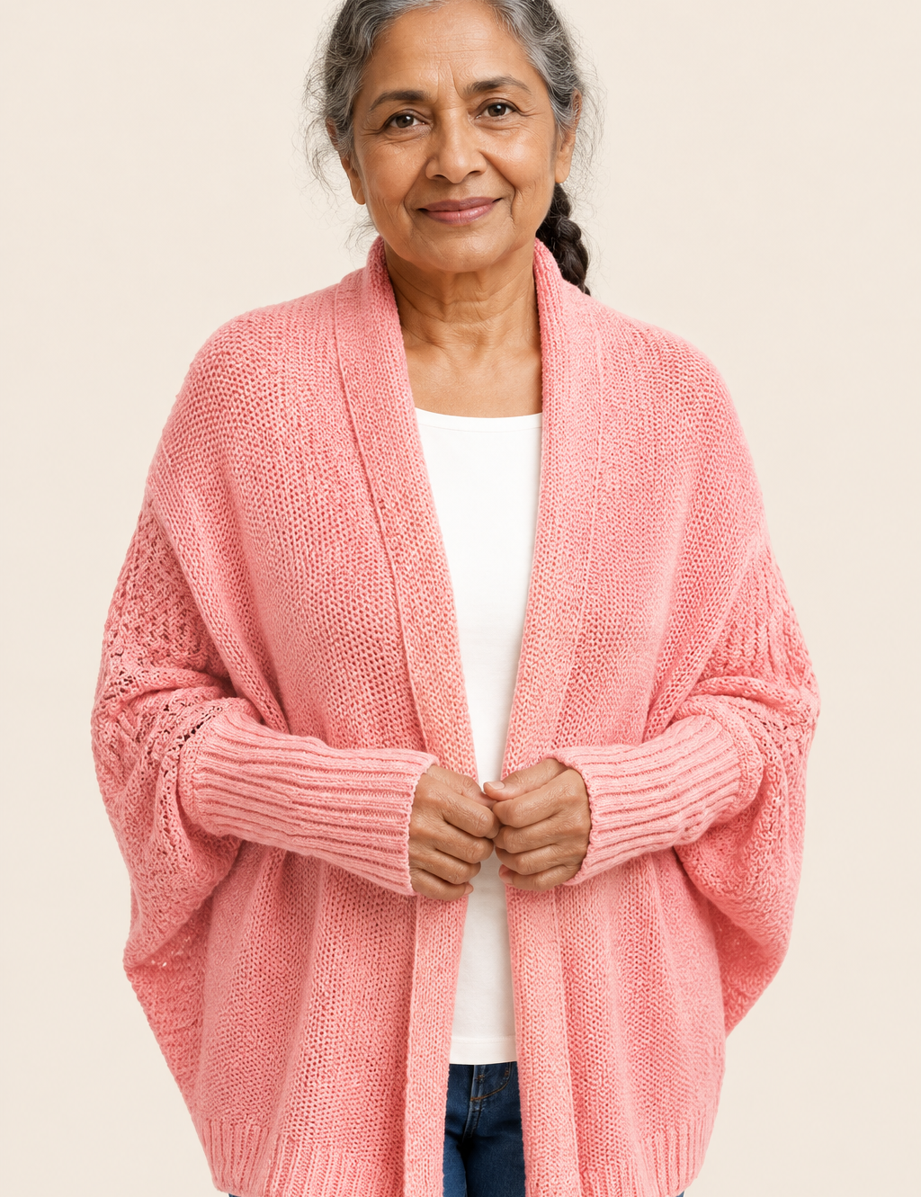 Dorina korallrosa Cocoon-Strickcardigan an reifer Frau auf warmem beigem Hintergrund