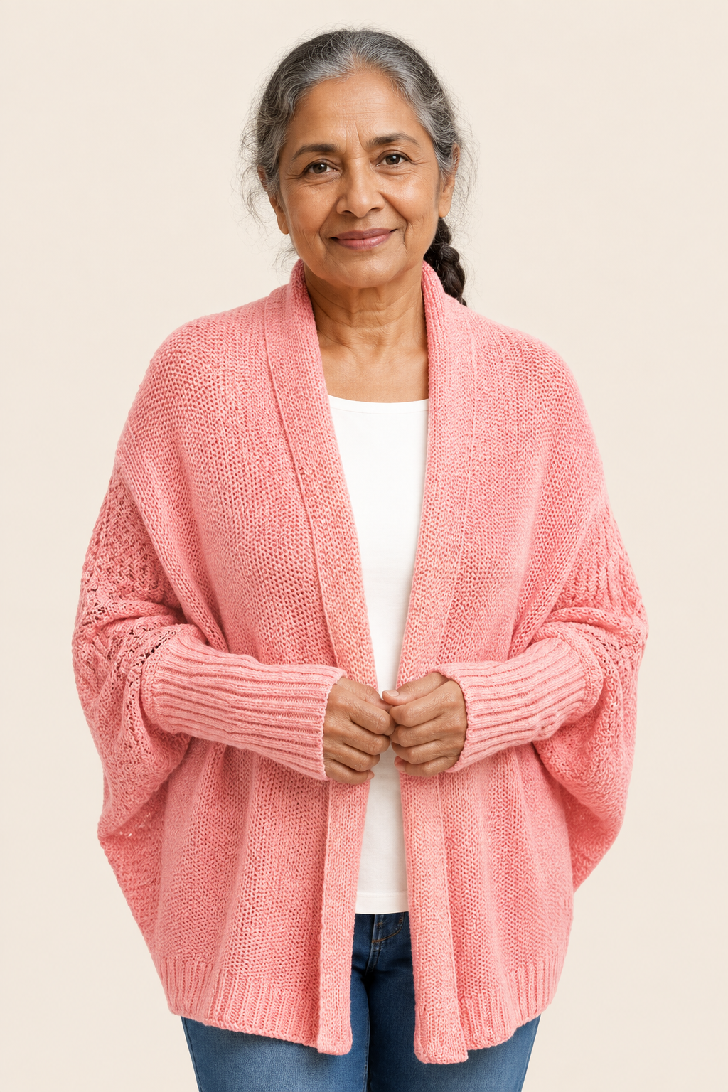Dorina korallrosa Cocoon-Strickcardigan an reifer Frau auf warmem beigem Hintergrund
