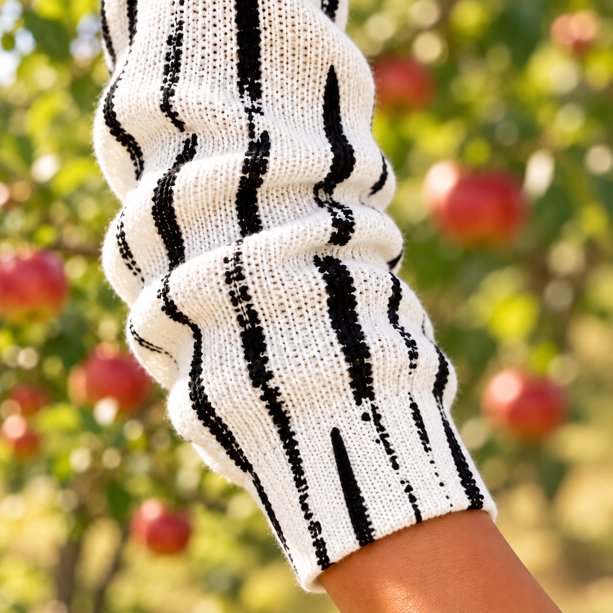 Detailansicht von Ärmel und Bündchen der Perrine Strickjacke in Cremeweiß mit schwarzen Strichen