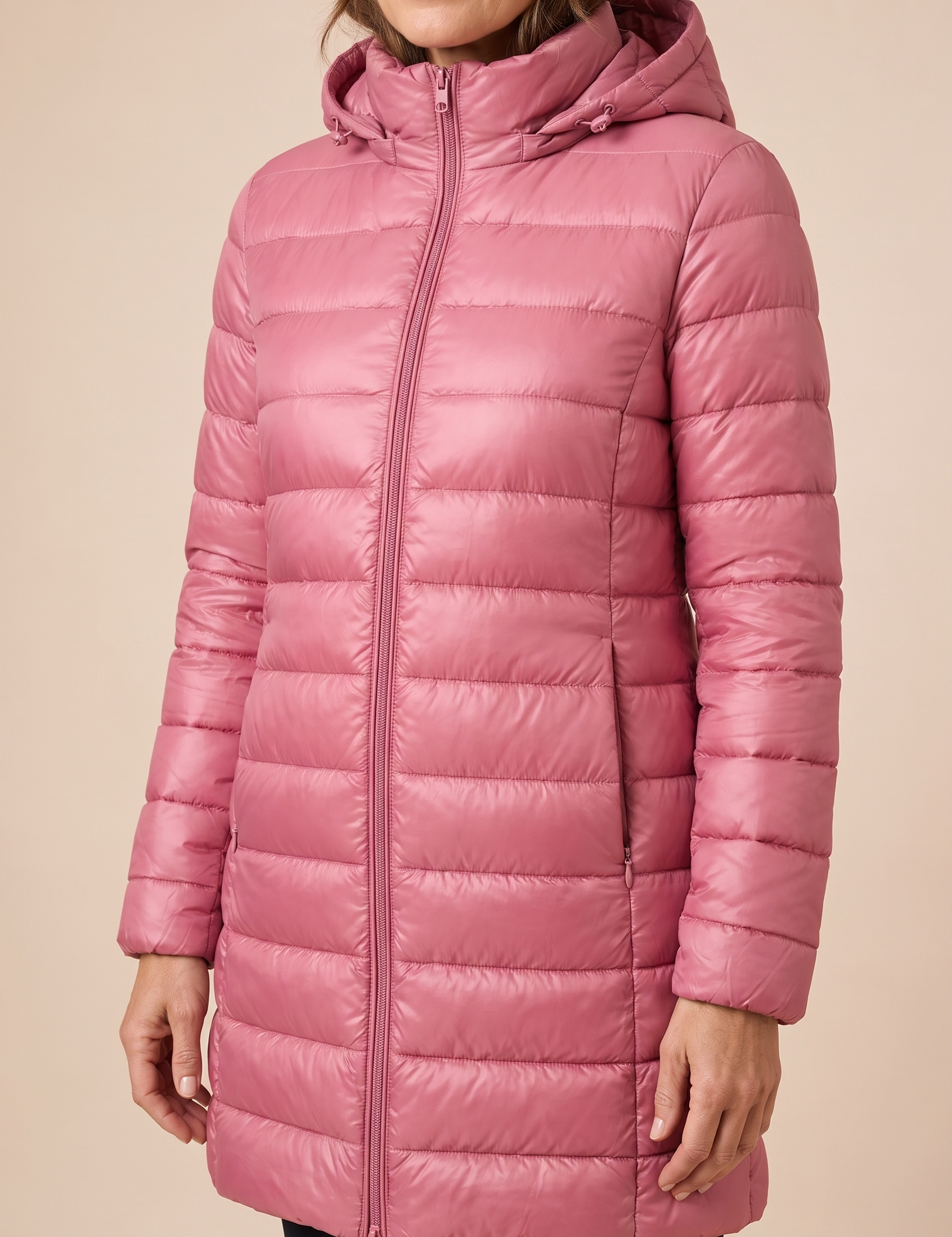 Ilinca | Ultraleichte Steppjacke mit Kapuze – Damenjacke auf warmem beigem Hintergrund, Oberkörperaufnahme