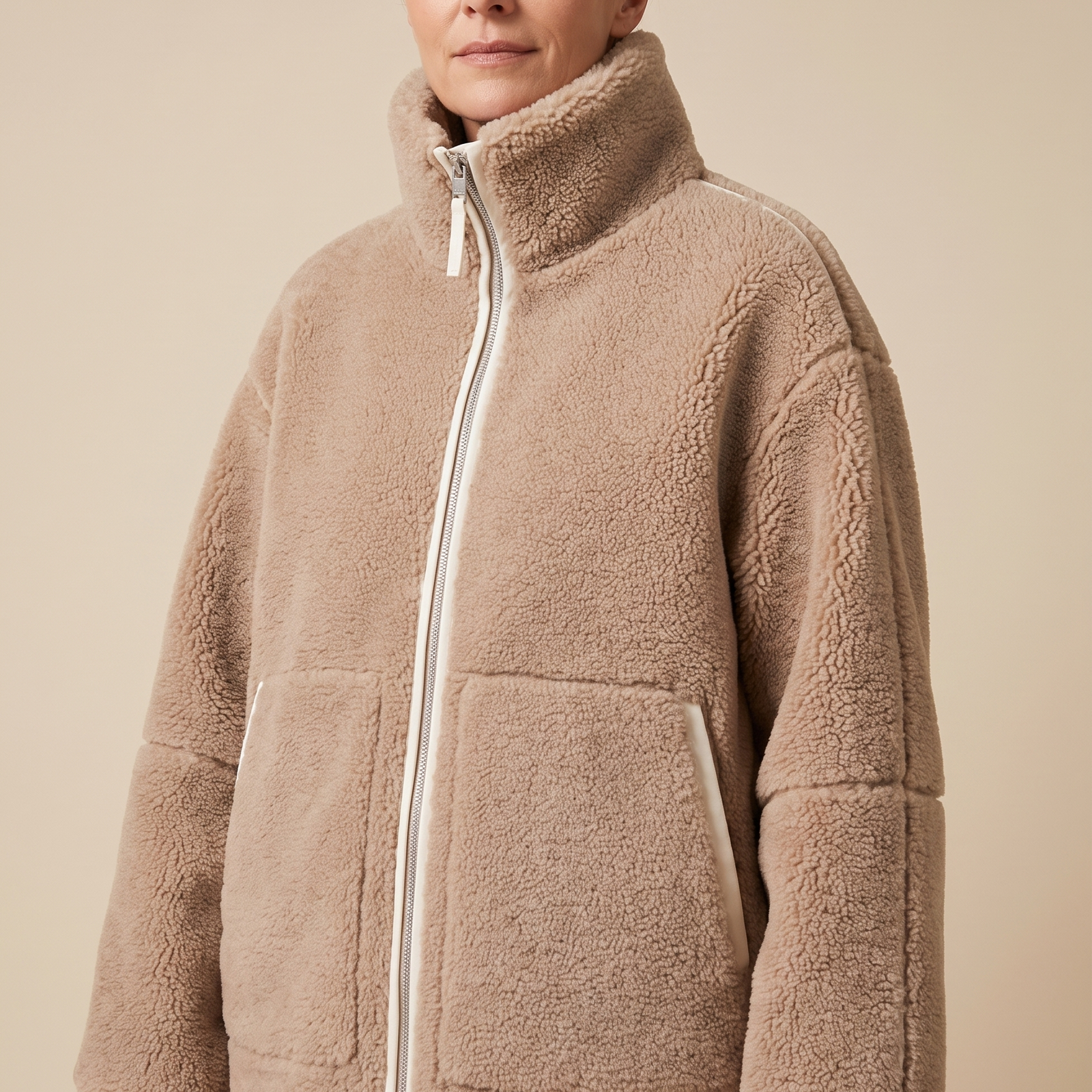 Carmen | Weiche Winterjacke – Damenjacke auf warmem beigem Hintergrund, Oberkörperaufnahme