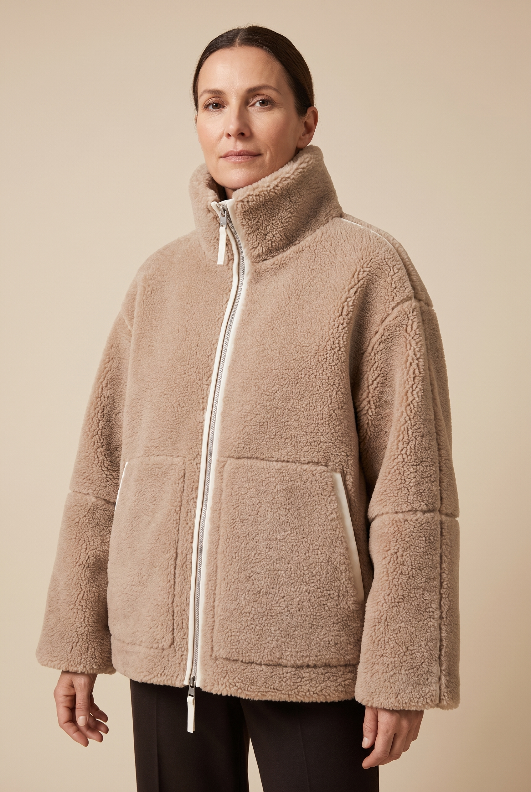 Carmen | Weiche Winterjacke – Damenjacke auf warmem beigem Hintergrund, Oberkörperaufnahme