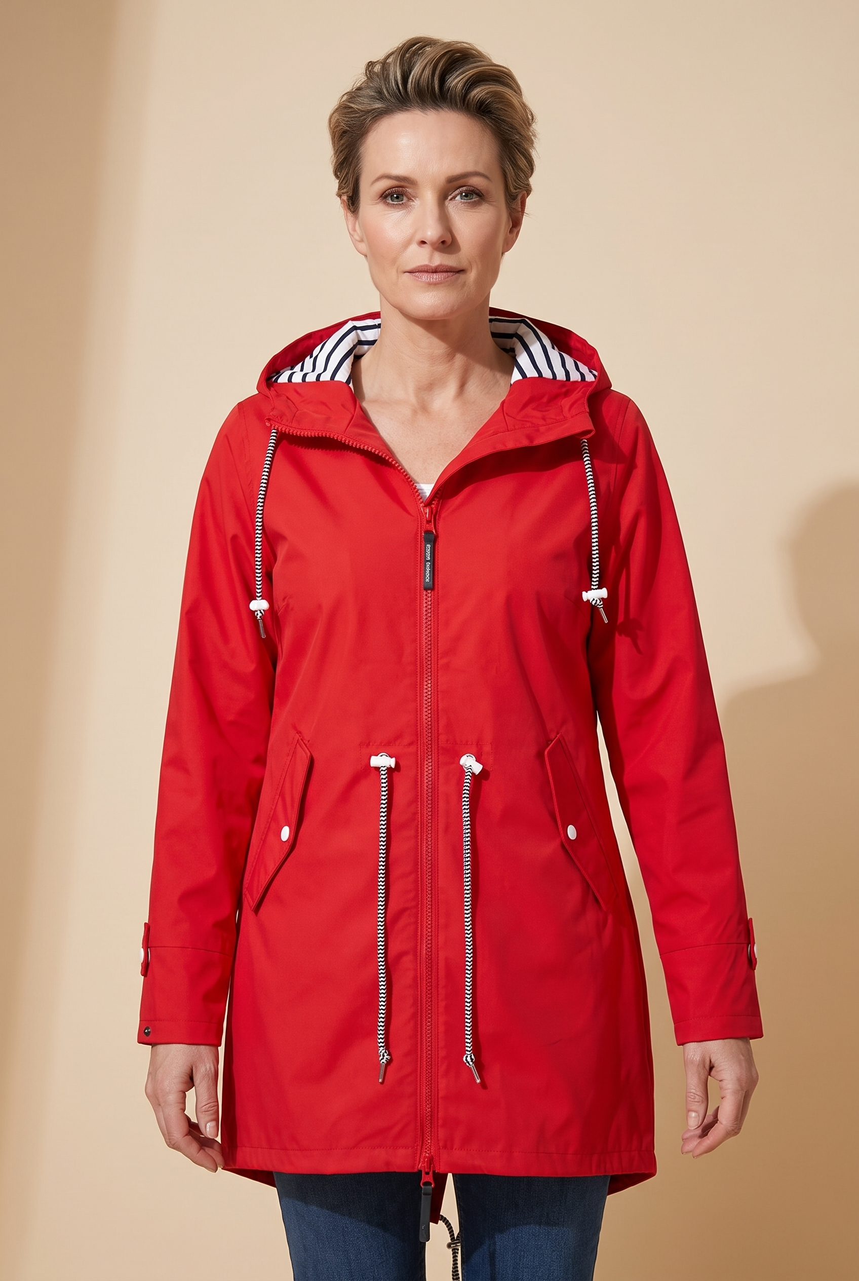 Renata | Elegante und wasserdichte Jacke – Damenjacke auf warmem beigem Hintergrund, Oberkörperaufnahme