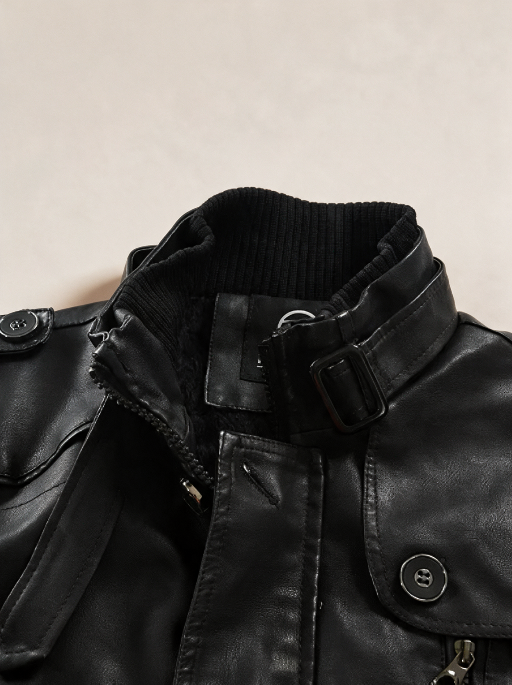 Elegante lange Leder-Bikerjacke – Produktfoto auf warmem beigem Hintergrund