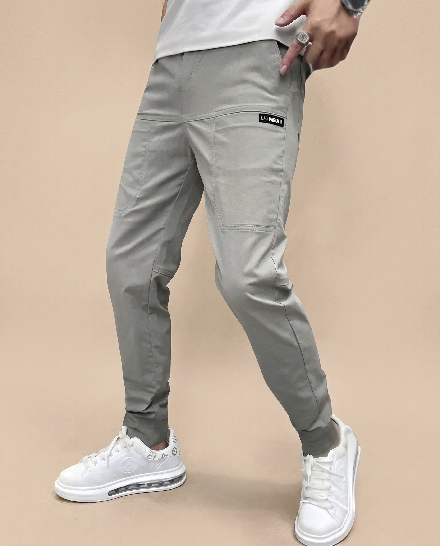 Herrenhose auf warmbeigem Hintergrund #E8DED2 mit männlichem Modell