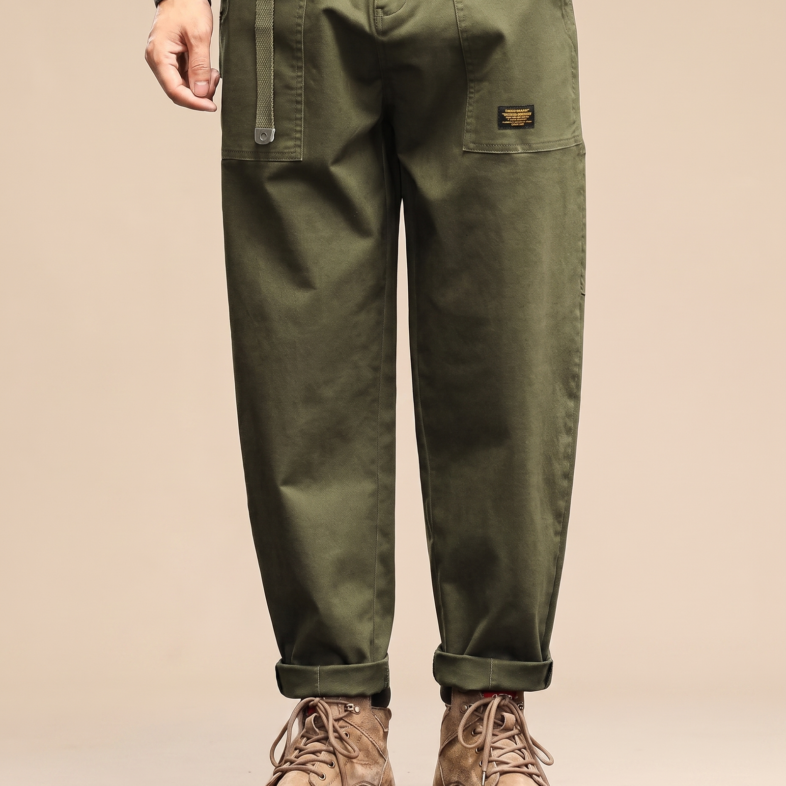 Herrenhose auf warmbeigem Hintergrund #E8DED2 mit männlichem Modell