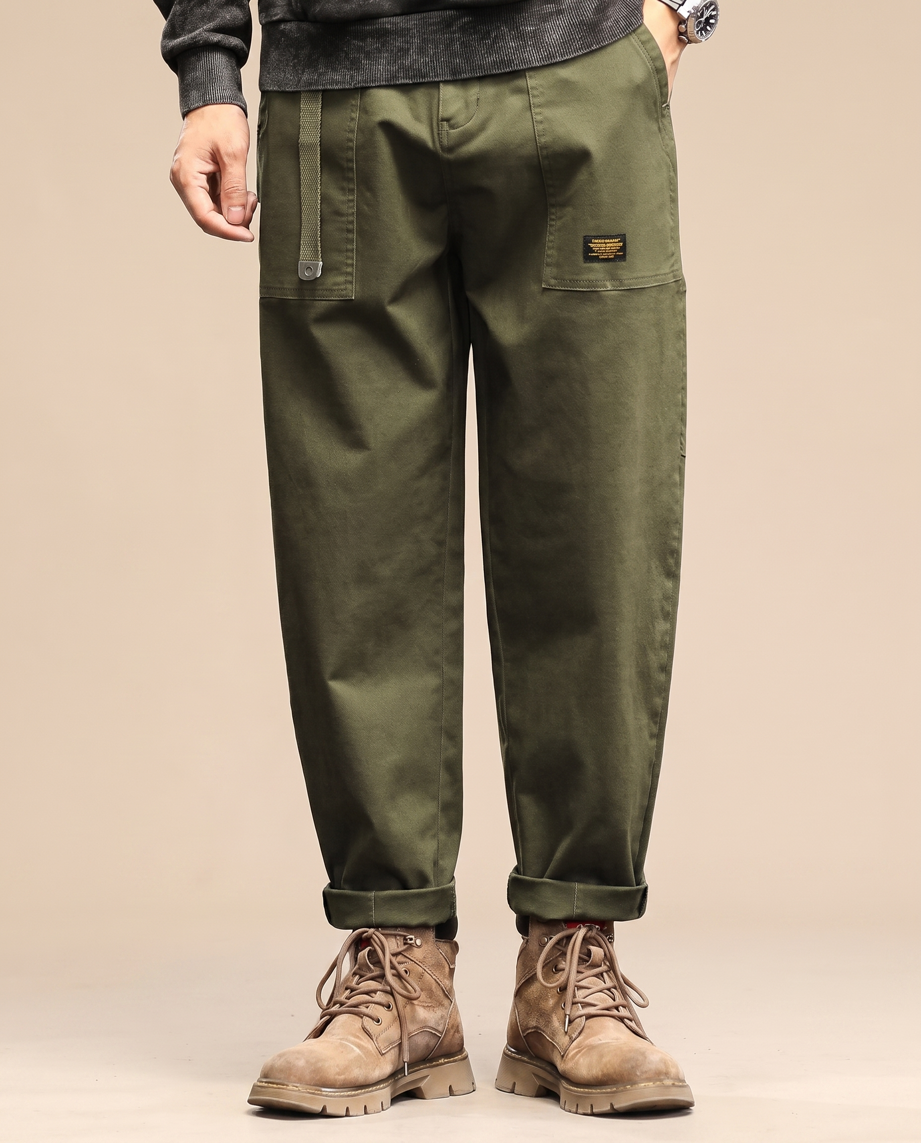 Herrenhose auf warmbeigem Hintergrund #E8DED2 mit männlichem Modell