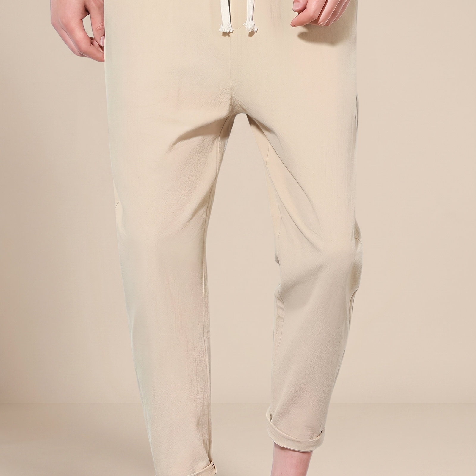 Herrenhose auf warmbeigem Hintergrund #E8DED2 mit männlichem Modell
