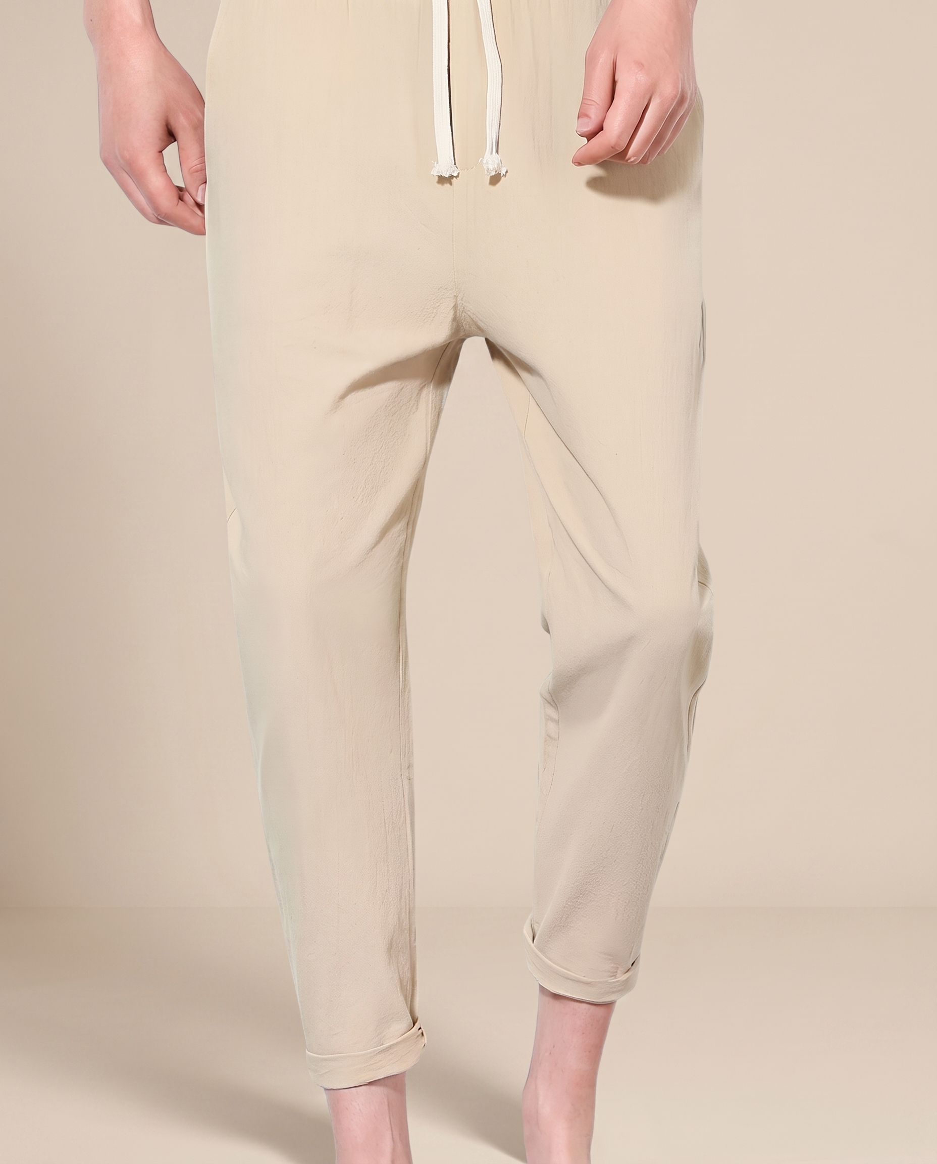 Herrenhose auf warmbeigem Hintergrund #E8DED2 mit männlichem Modell