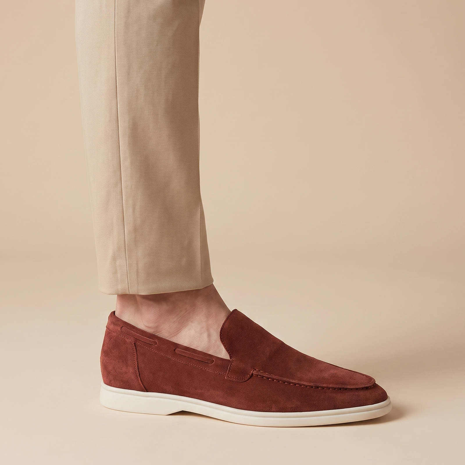 Herrenschuh auf warmbeigem Hintergrund #E8DED2 mit männlichem Modell