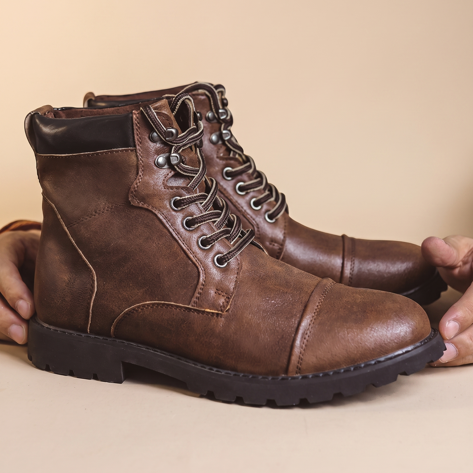 Herrenschuhe mit männlichem Model auf beigem Hintergrund