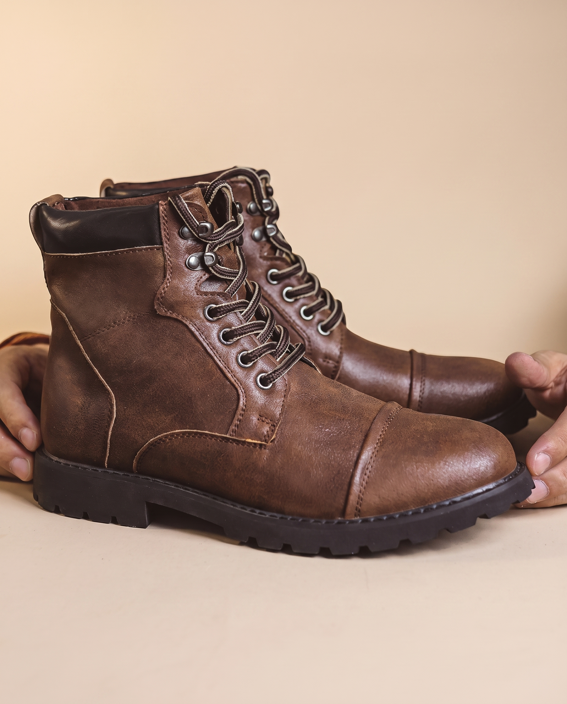 Herrenschuhe mit männlichem Model auf beigem Hintergrund
