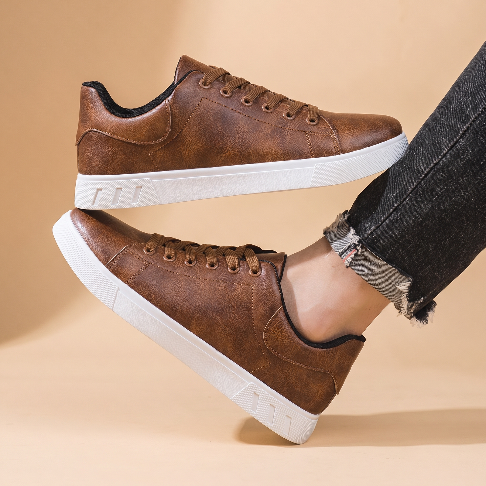 Herrenschuhe mit männlichem Model auf beigem Hintergrund