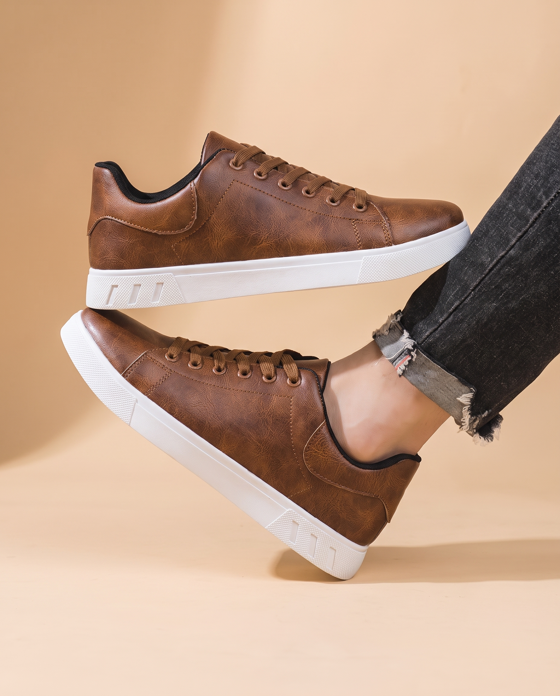 Herrenschuhe mit männlichem Model auf beigem Hintergrund