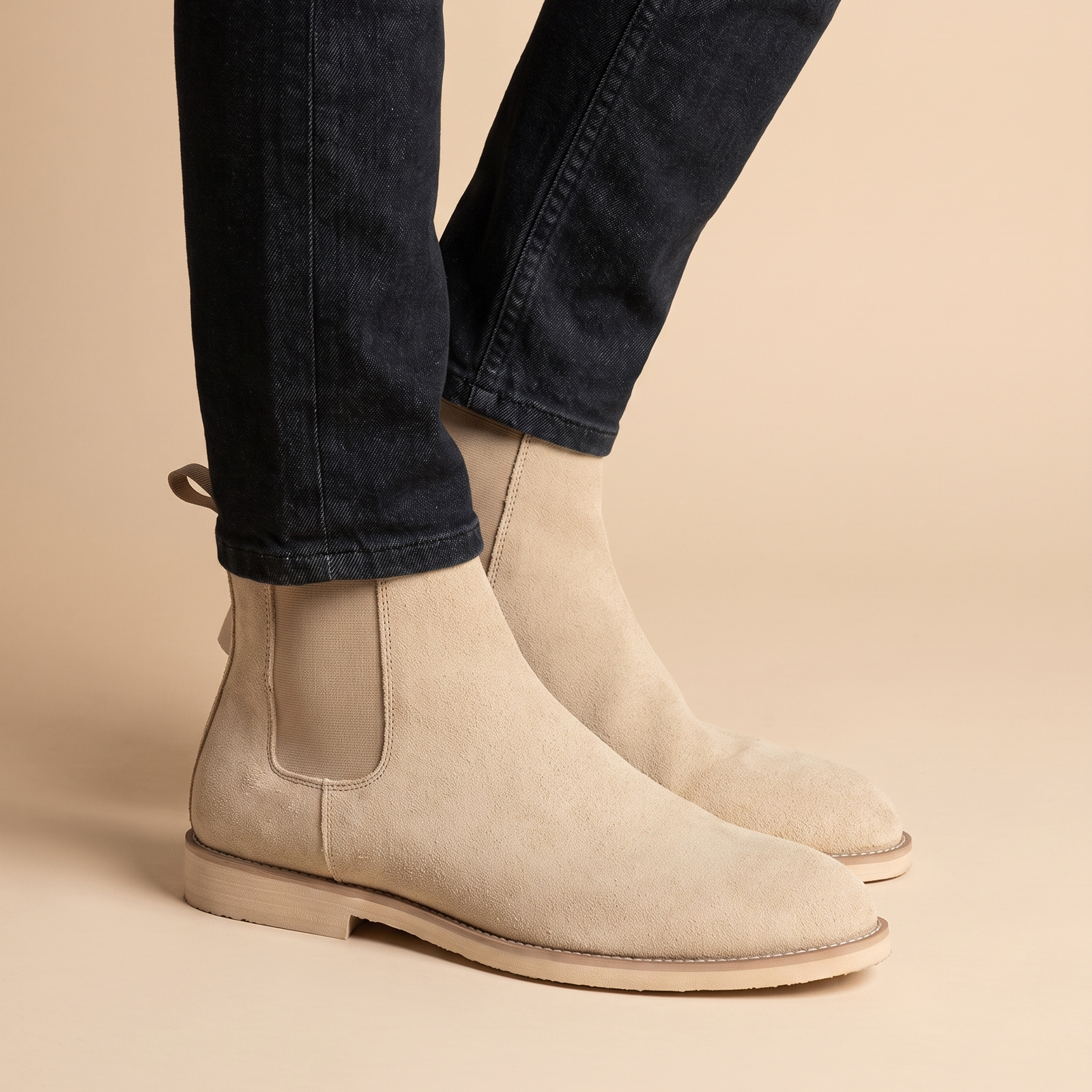 Herrenschuhe mit männlichem Model auf beigem Hintergrund