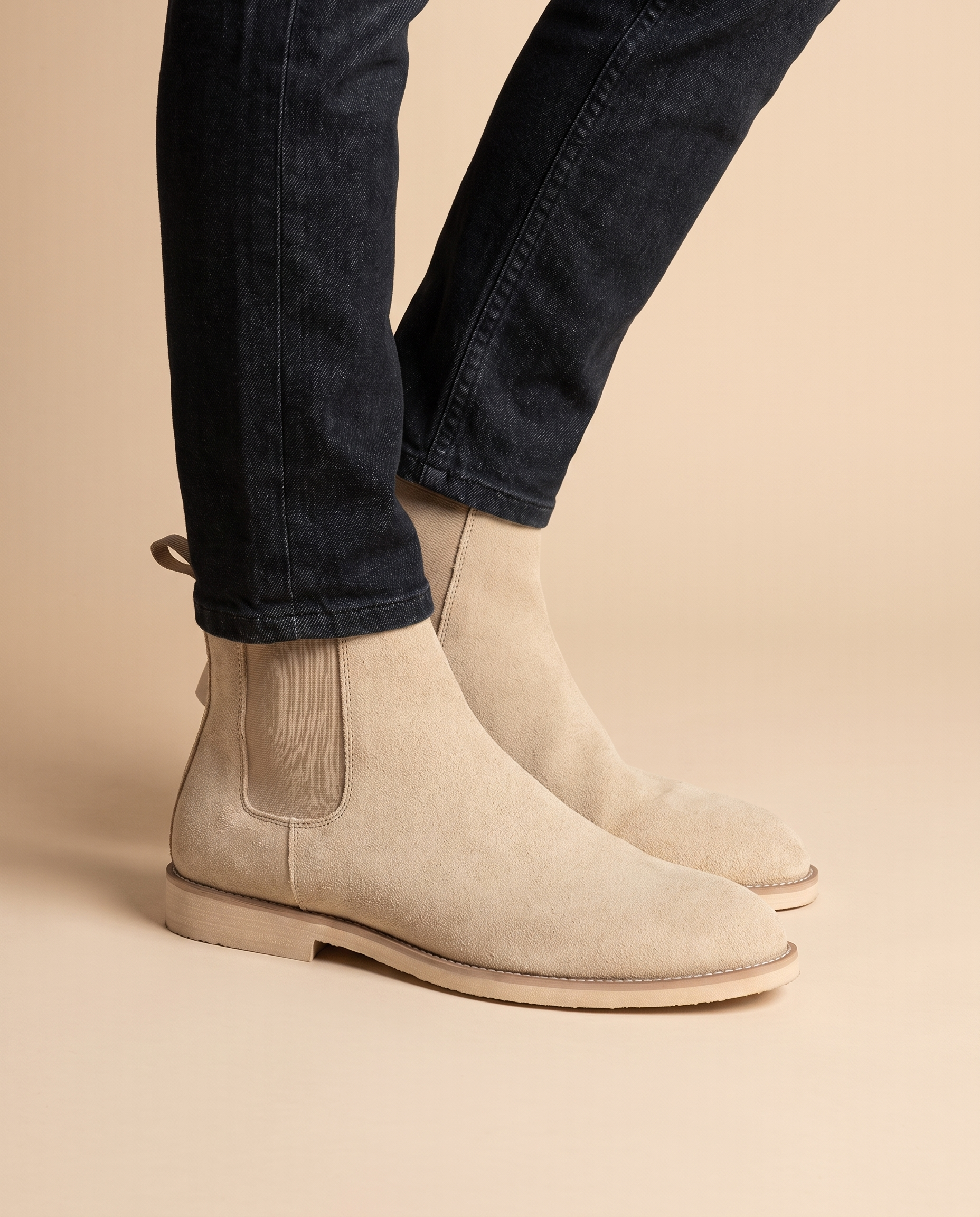 Herrenschuhe mit männlichem Model auf beigem Hintergrund