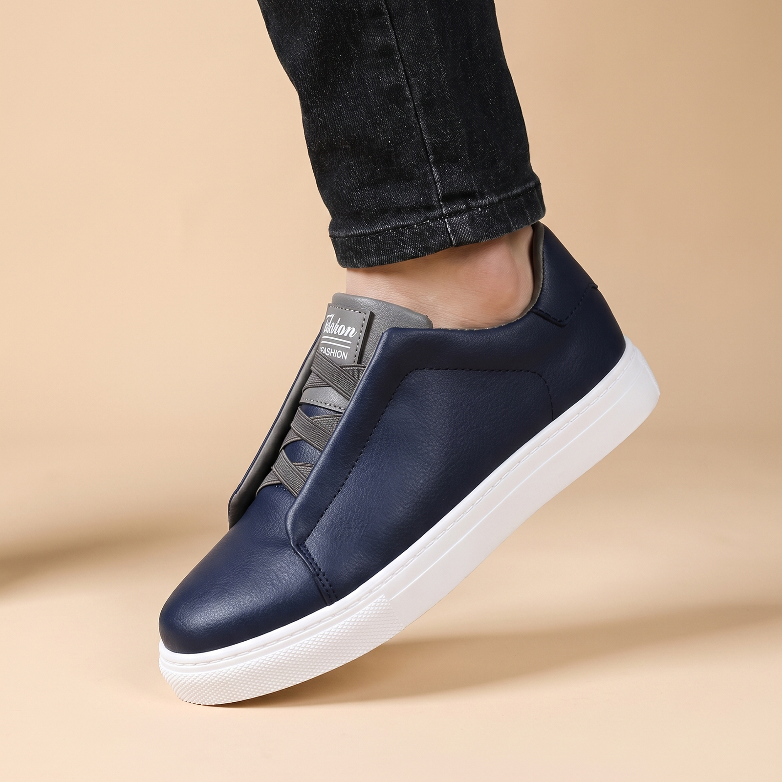 Herrenschuhe mit männlichem Model auf beigem Hintergrund