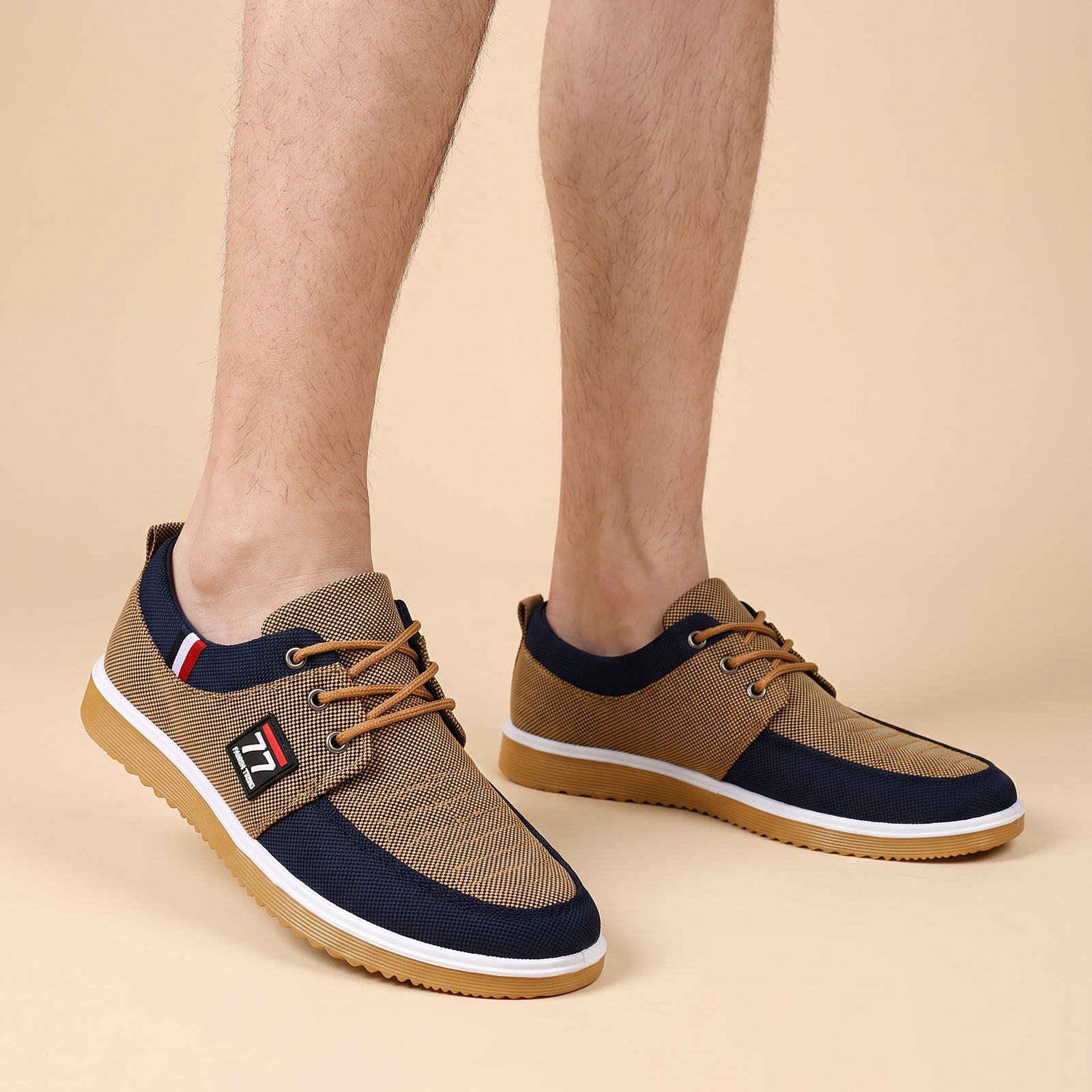 Herrenschuhe mit männlichem Model auf beigem Hintergrund