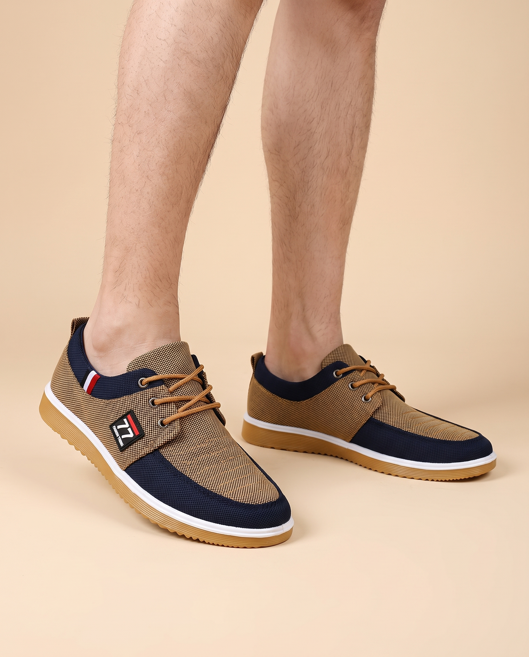 Herrenschuhe mit männlichem Model auf beigem Hintergrund