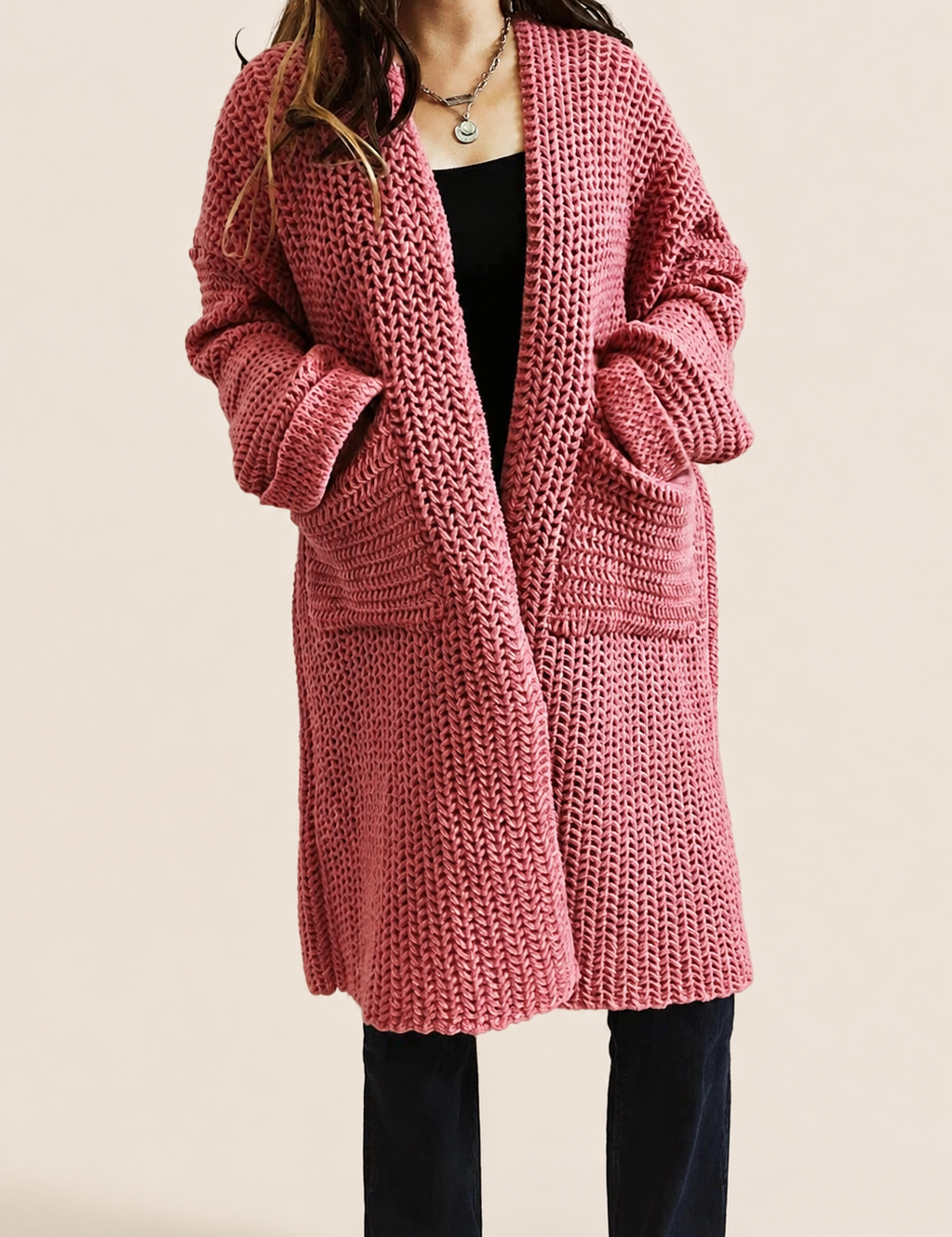 Grober rosa Oversize-Strickcardigan auf warmem beigem Hintergrund