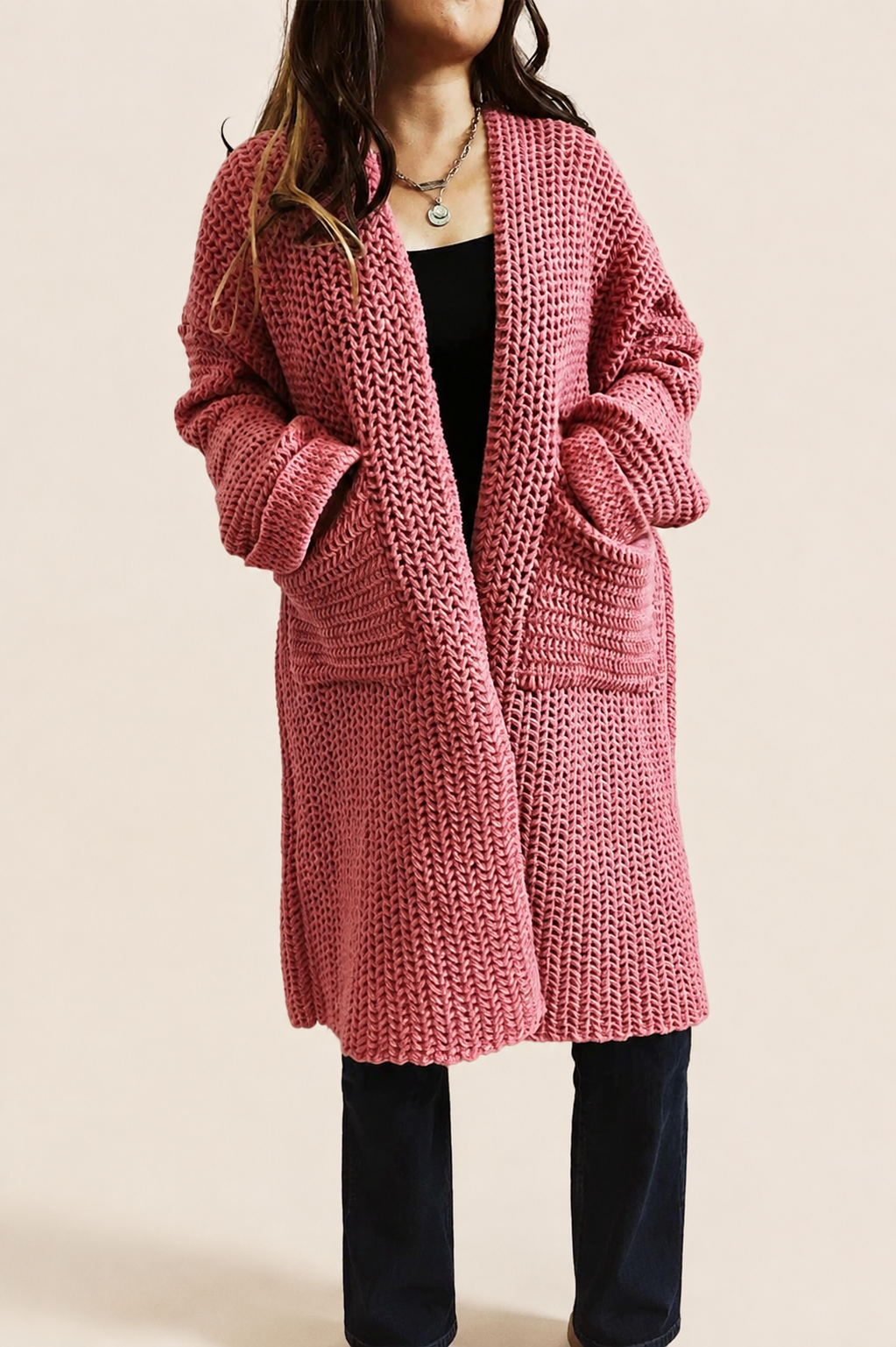 Grober rosa Oversize-Strickcardigan auf warmem beigem Hintergrund