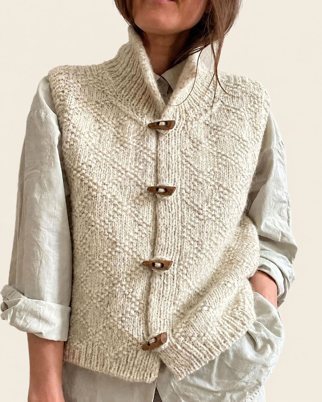 Ingrid | Kuschelig gestrickt ärmellos Cardigan – warmbeiger Studiohintergrund