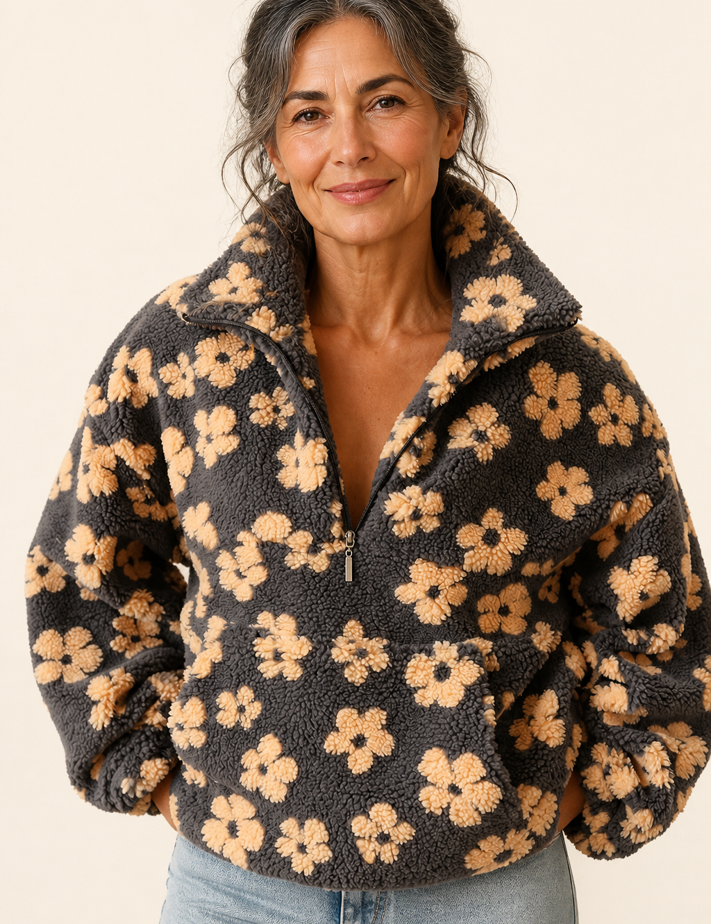 Isabela grauer Sherpa-Pullover mit Blumen an reifer Frau auf warmem beigem Hintergrund