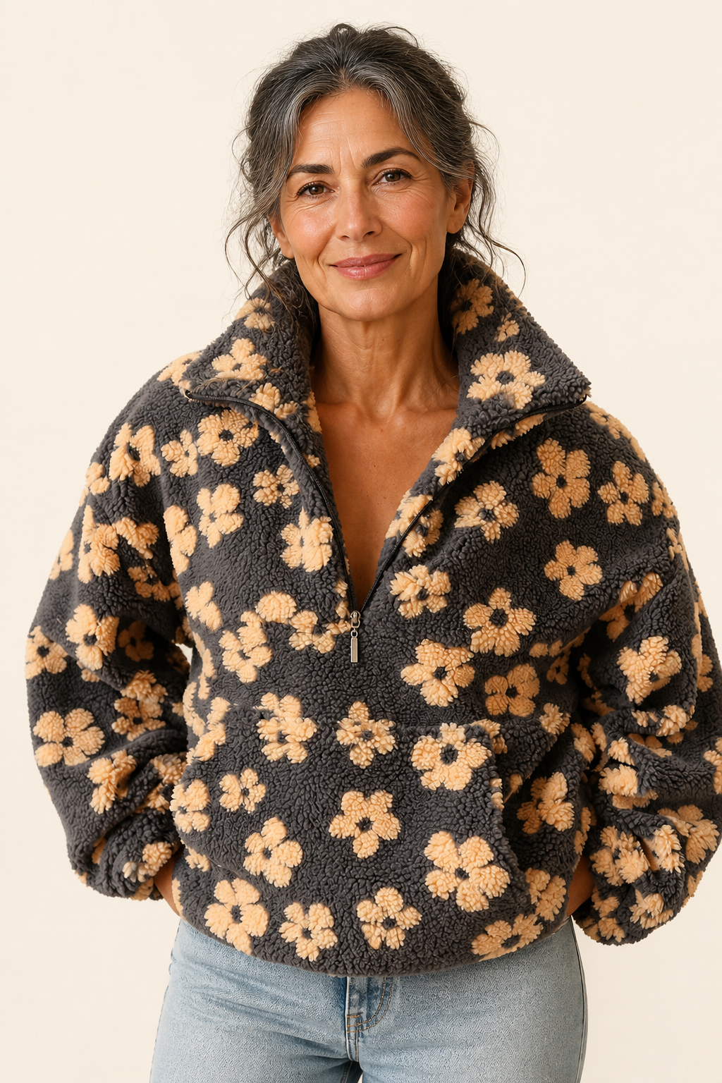 Isabela grauer Sherpa-Pullover mit Blumen an reifer Frau auf warmem beigem Hintergrund