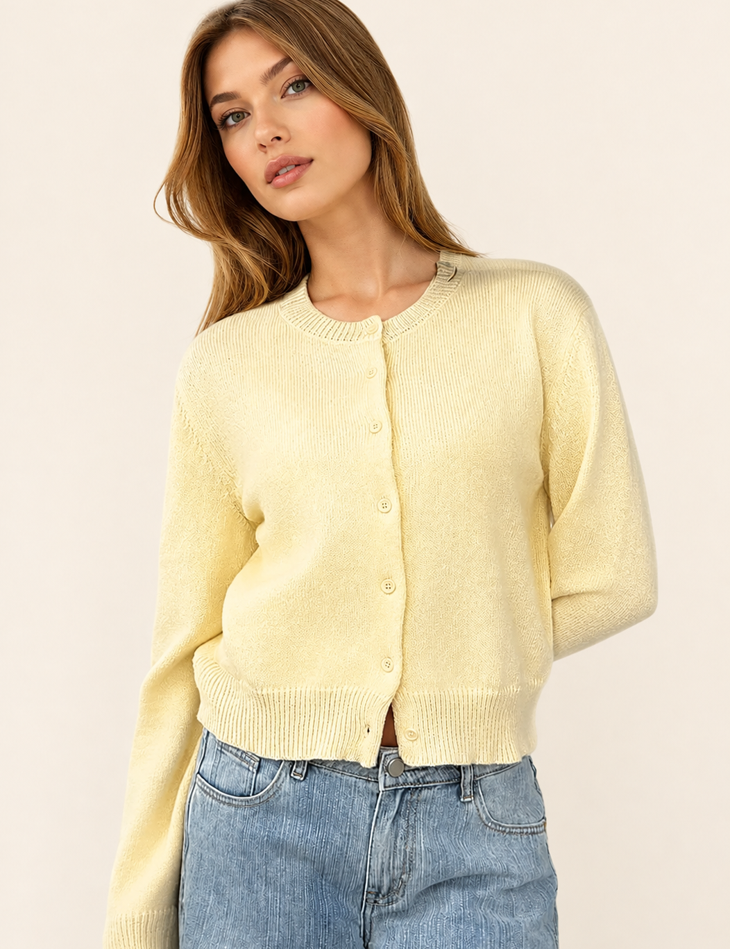 Klassische cremefarbene Damen-Strickjacke auf warmem beigem Hintergrund