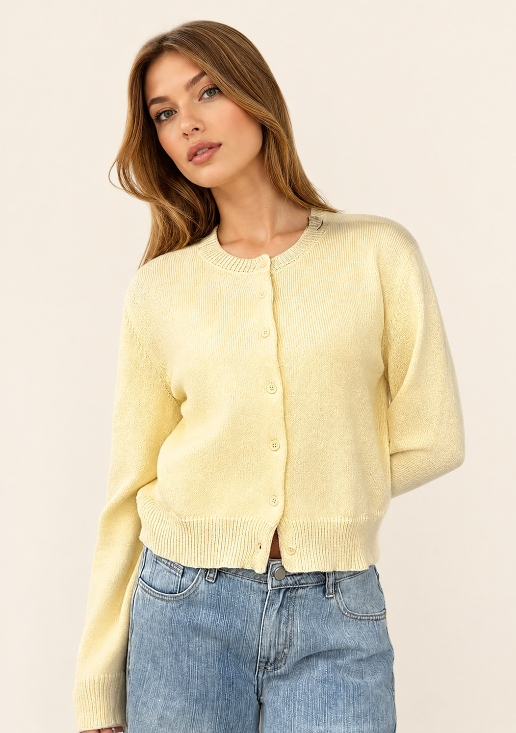 Klassische cremefarbene Damen-Strickjacke auf warmem beigem Hintergrund