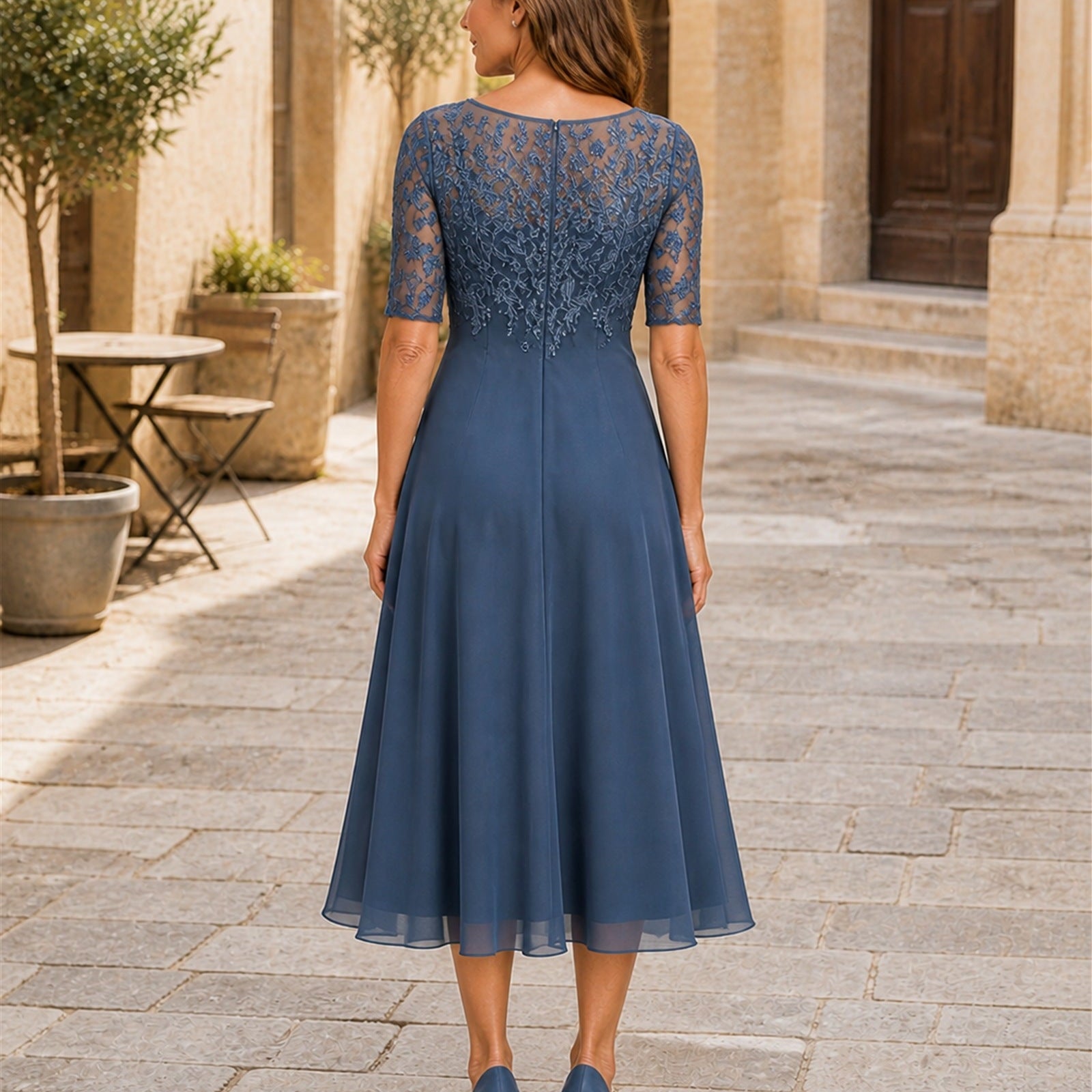 Laura în rochie elegantă albastră cu corsaj brodat, vedere din spate