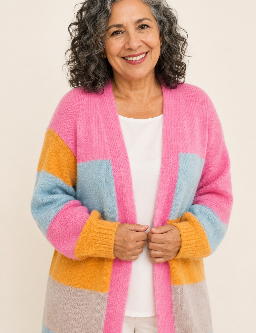 Malvina pastellfarbener Colorblock-Cardigan an reifer Frau auf warmem beigem Hintergrund
