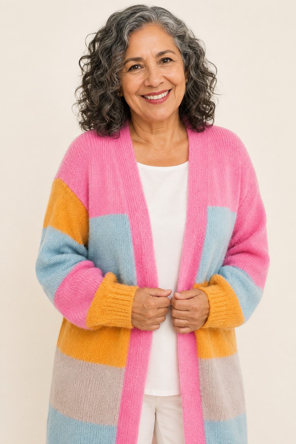 Malvina pastellfarbener Colorblock-Cardigan an reifer Frau auf warmem beigem Hintergrund