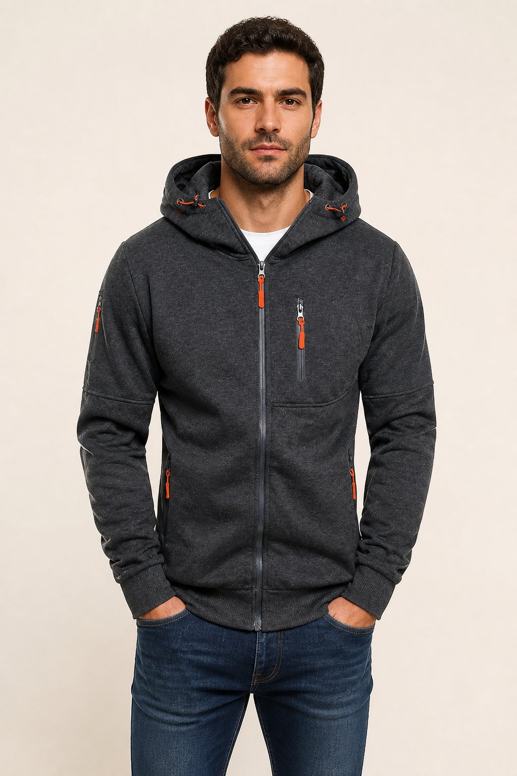 Marco anthrazitfarbene Kapuzenjacke mit orangefarbenen Details an Mann auf warmem beigem Hintergrund