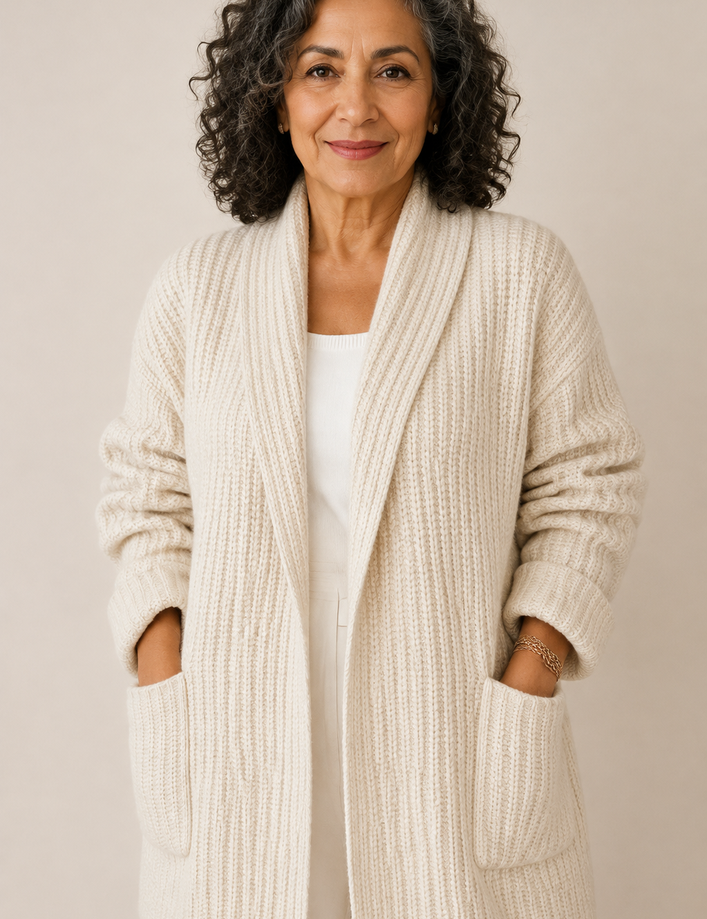 Maria-Irina cremefarbene Strickjacke mit Taschen an reifer Frau auf warmem beigem Hintergrund