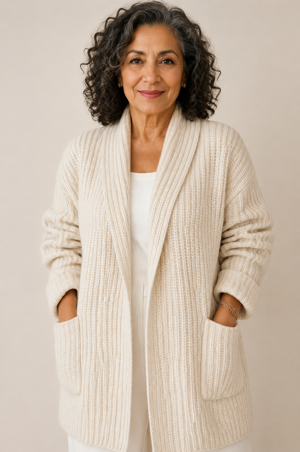 Maria-Irina cremefarbene Strickjacke mit Taschen an reifer Frau auf warmem beigem Hintergrund