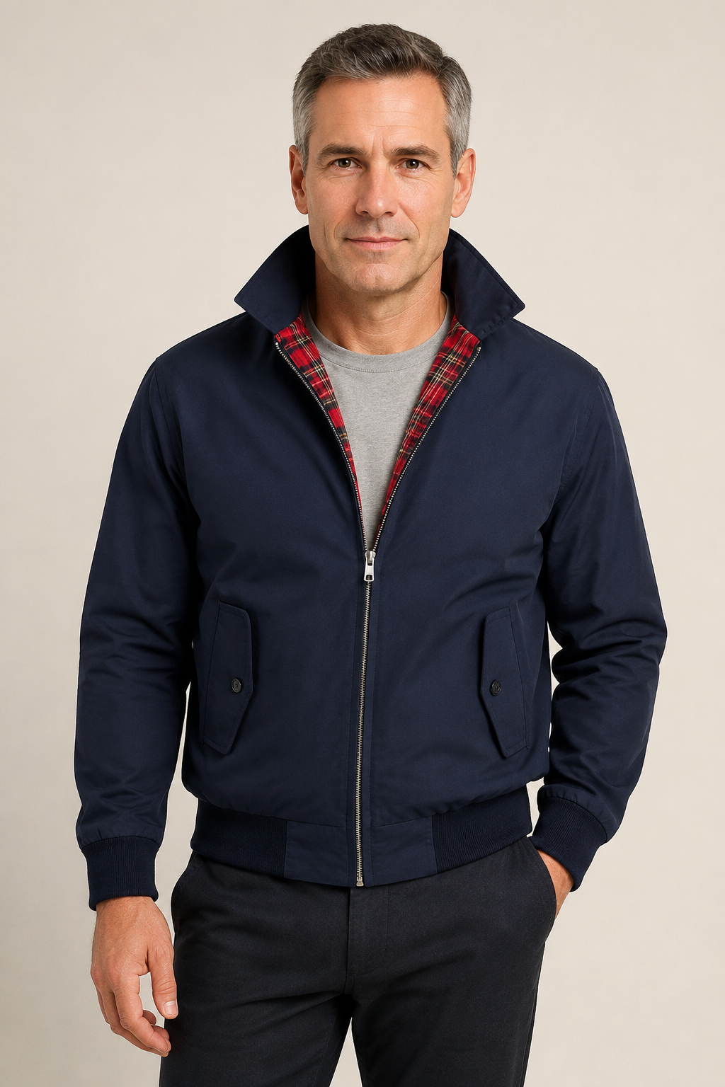 Marineblaue Bomberjacke mit Tartanfutter an Mann auf beigem Hintergrund