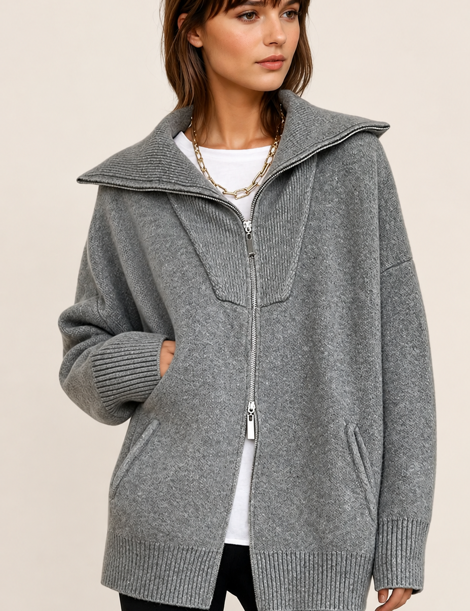 Grauer Oversize-Cardigan mit offenem Kragen auf warmem beigem Hintergrund