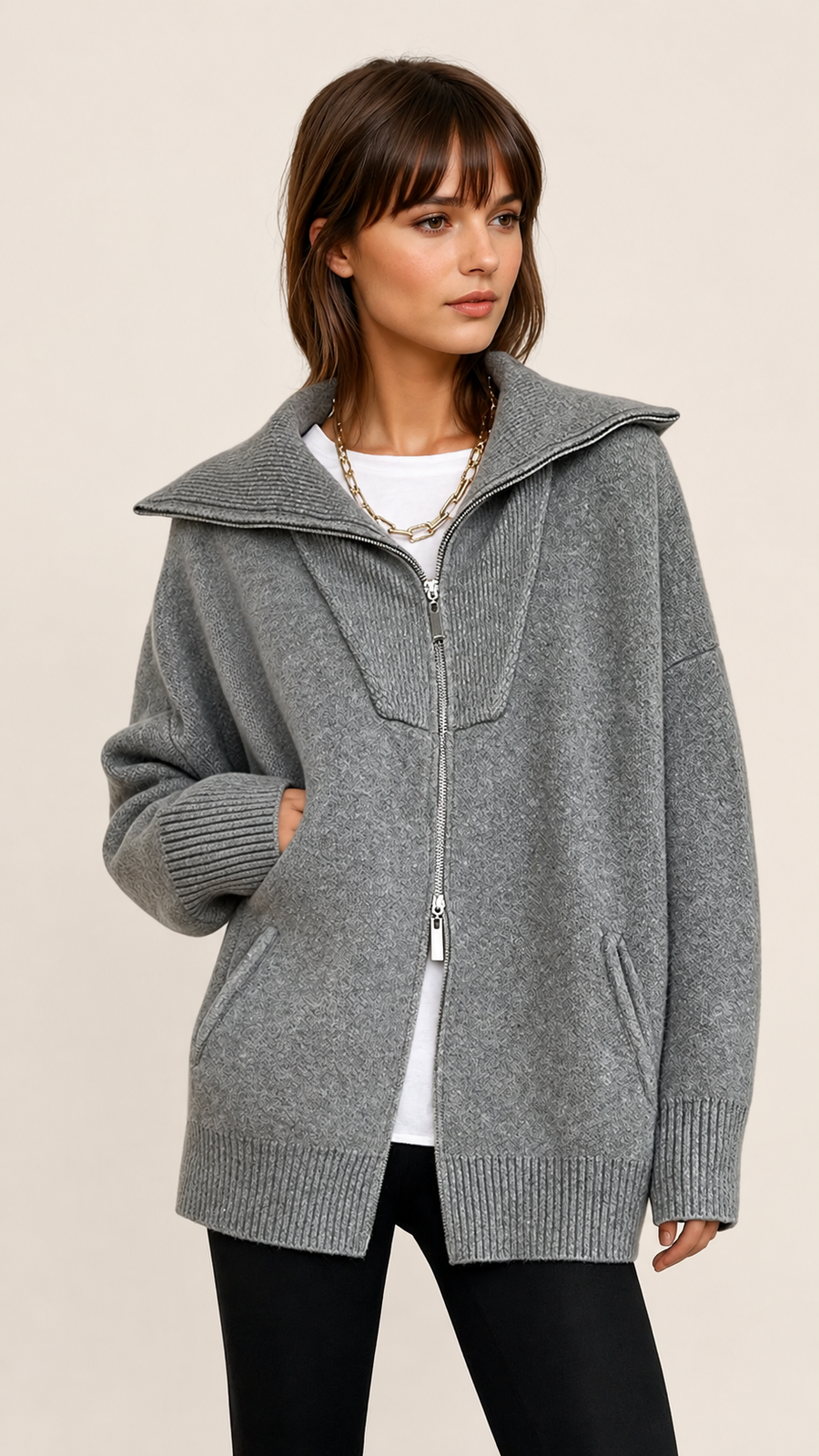 Grauer Oversize-Cardigan mit offenem Kragen auf warmem beigem Hintergrund